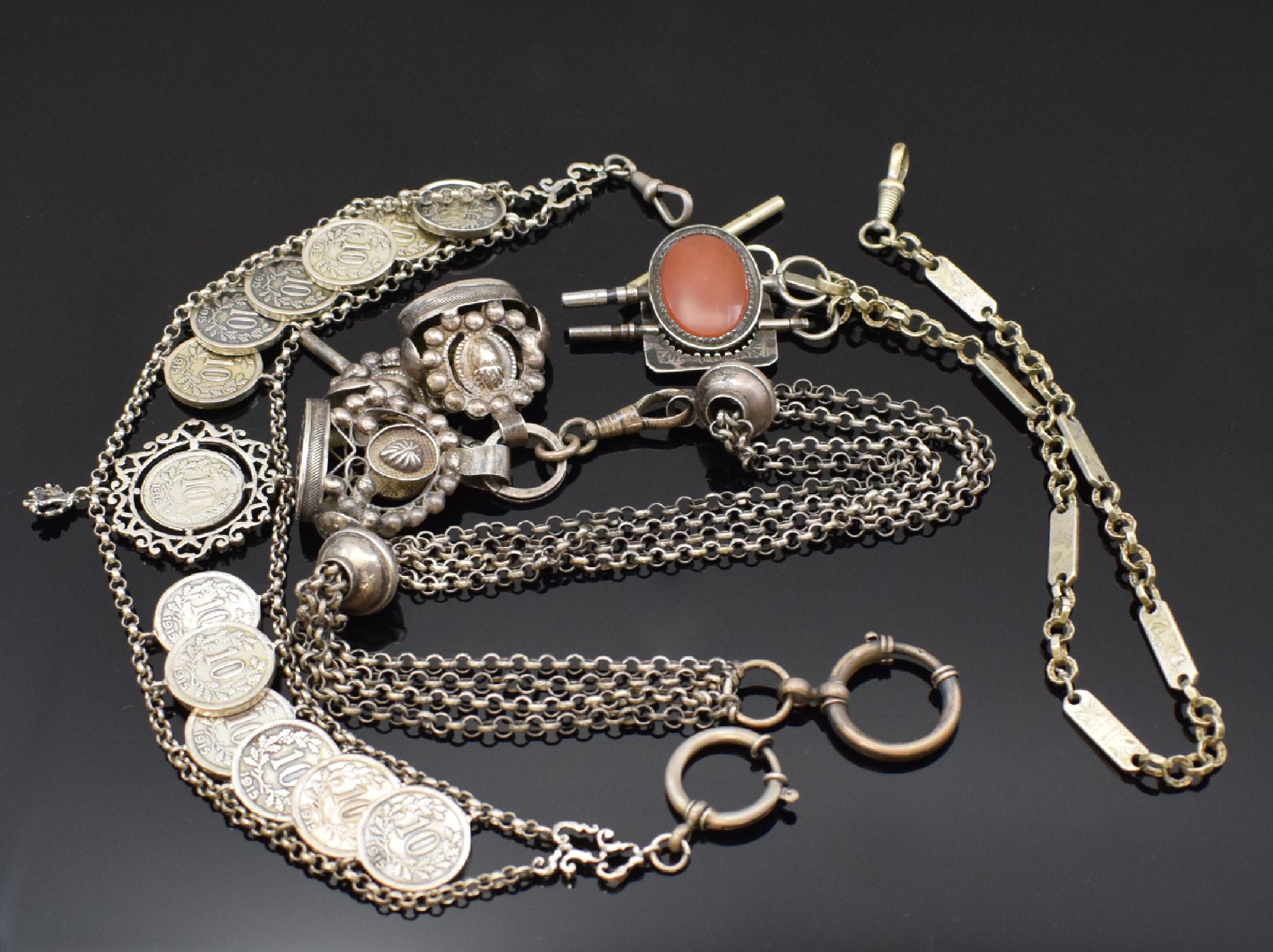 2 vernickelte und 1 Silber-Taschenuhrkette, um 1872-1915, 1) Kette m. Taschenuhrschlüssel 1x m. Karneol, 1x Stein fehl., Karabiner, L. ca. 35,5 ...