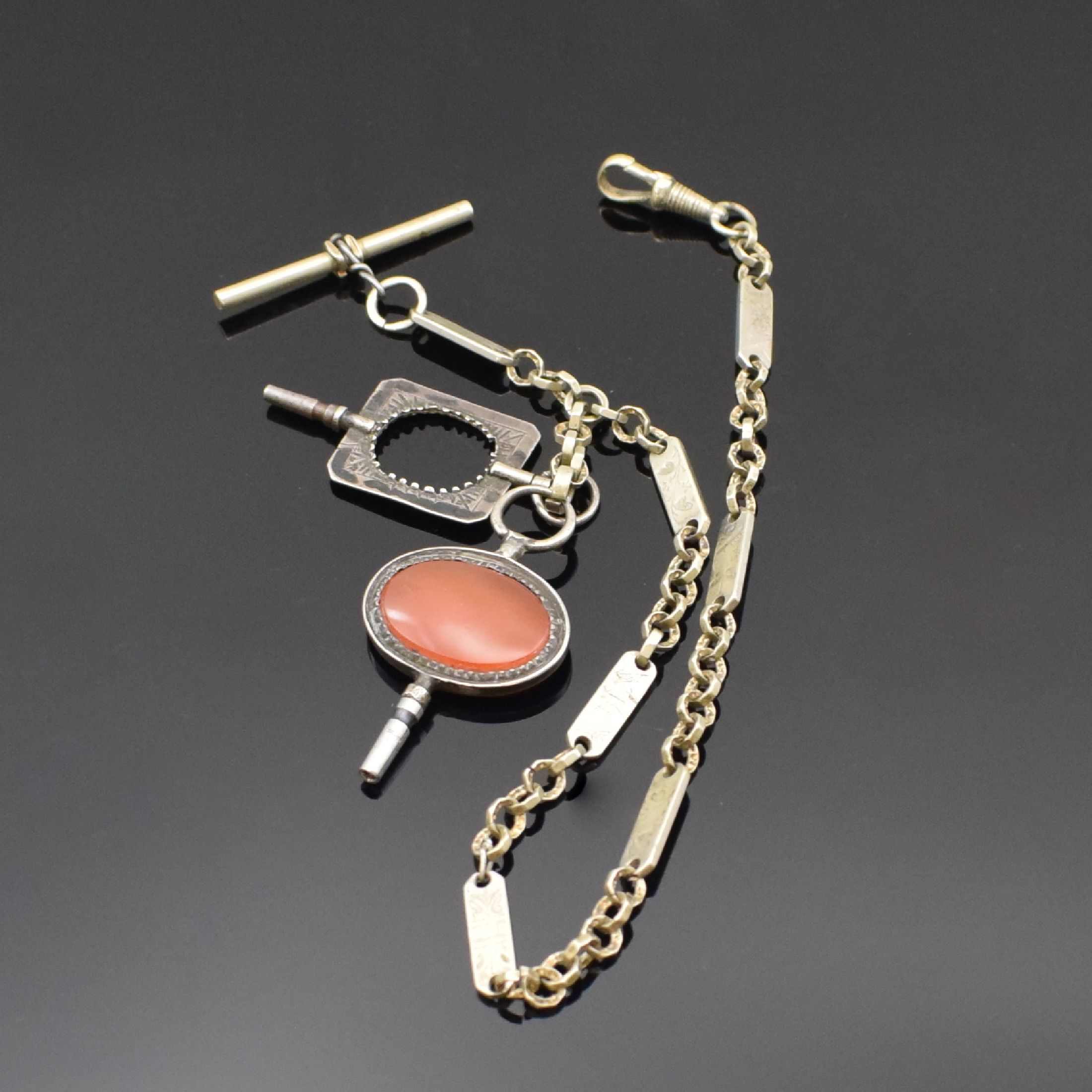 Detail d: 2 vernickelte und 1 Silber-Taschenuhrkette, um 1872-1915, 1) Kette m. Taschenuhrschlüssel 1x m. Karneol, 1x Stein fehl., Karabiner, L. ca. 35,5 ...