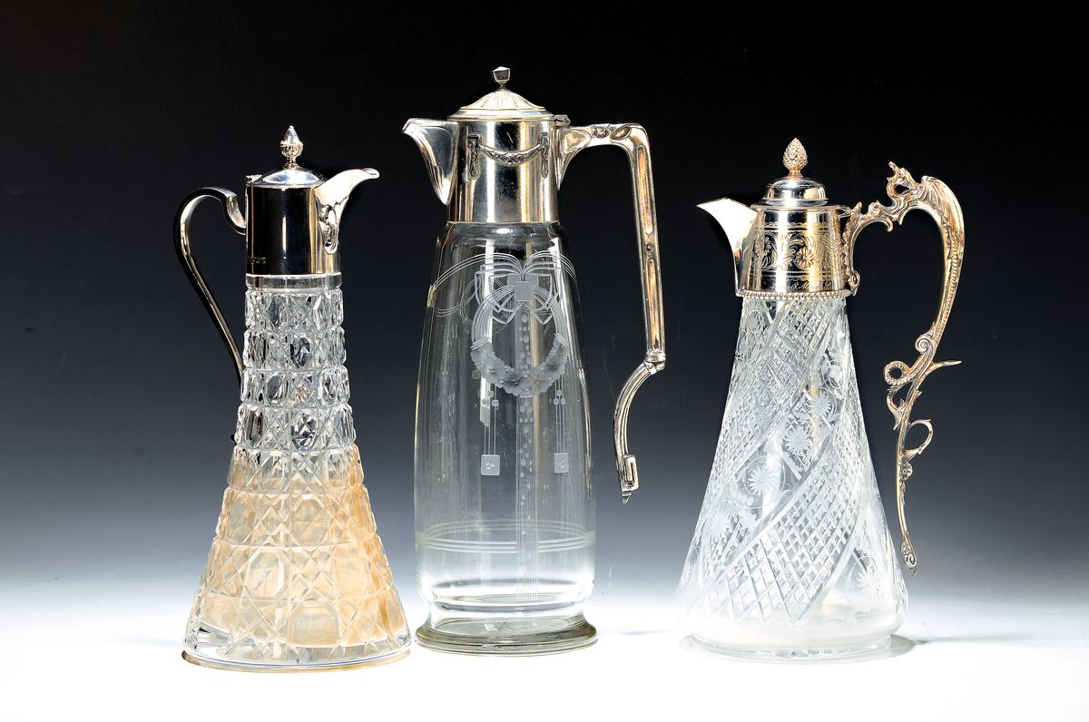 Drei Karaffen, Jugendstil und später, 1. englisch, mit geschliffenem Glaskorpus, dieser innen verschmutzt, H. ca. 30 cm, 2. um 1890/1900, ...