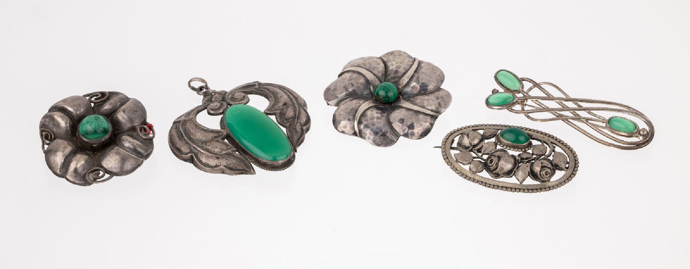 Konvolut 4 Broschen und 1 Anhänger mit Grünachat bzw. Malachit, 1930er bis 1960er Jahre, abstr.-florale Designs, Rosenmuster, z.T. ...