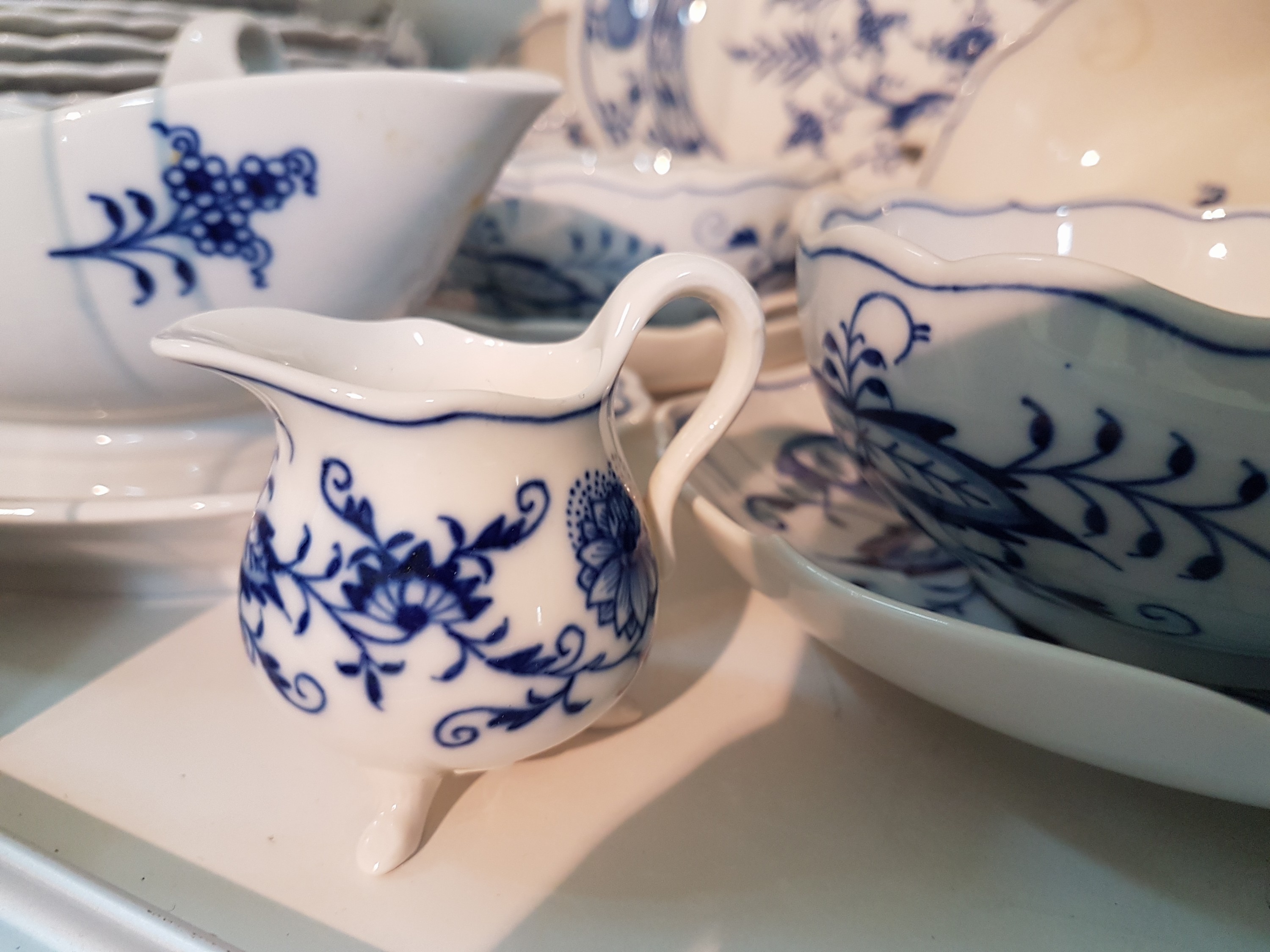 Detail g: Tafelservice, Meissen, Zwiebelmuster, meist 20. Jh., 12 Menueteller, 12 Suppentassen mit Untertassen (1x mit Chip), 7 Desserttellermit ...