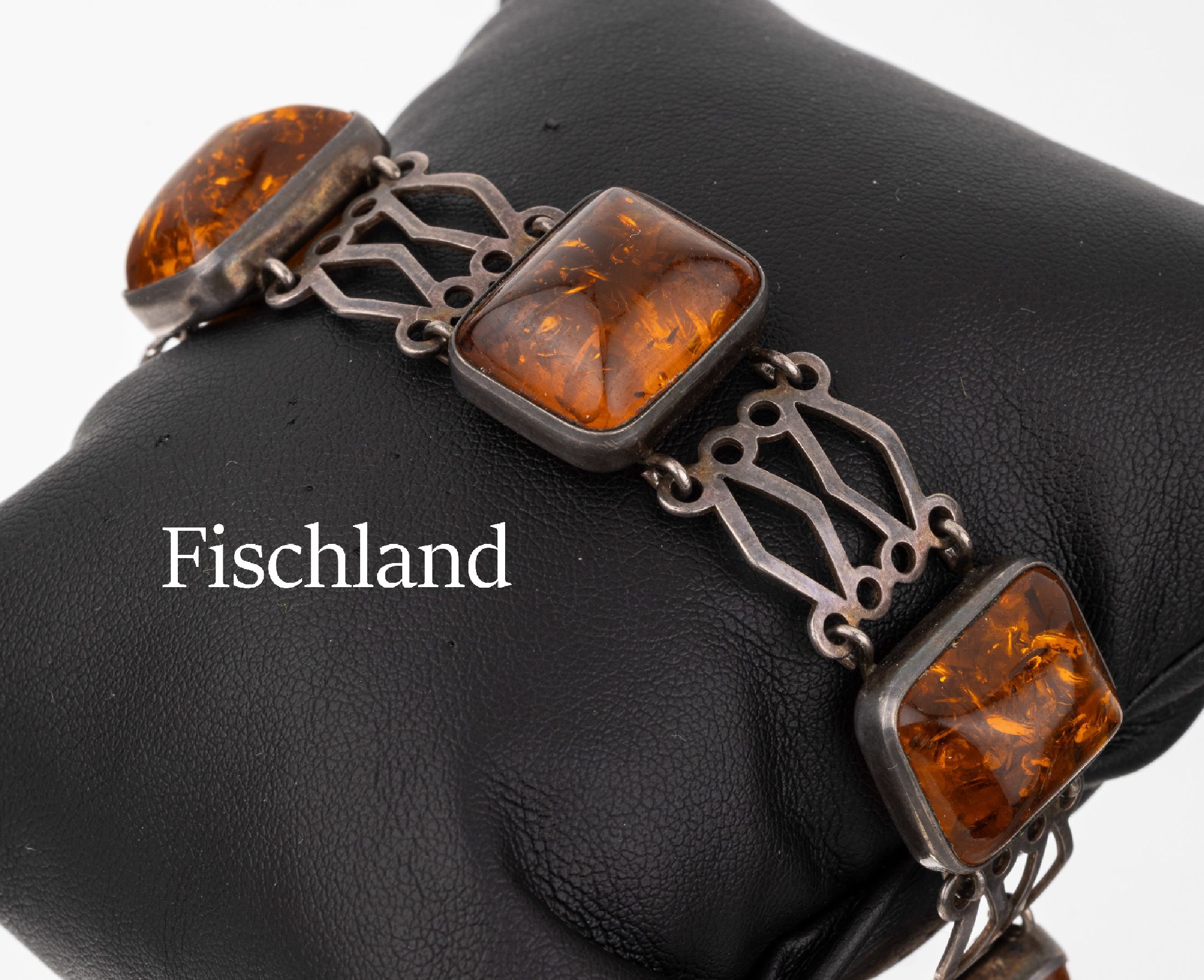 FISCHLAND Bernstein-Armband, 835er Silber, um 1940, 5 Bernsteincabochons, Verbindungen durchbrochen gearbeitet, L. ca. 18 cm, Steckverschluss