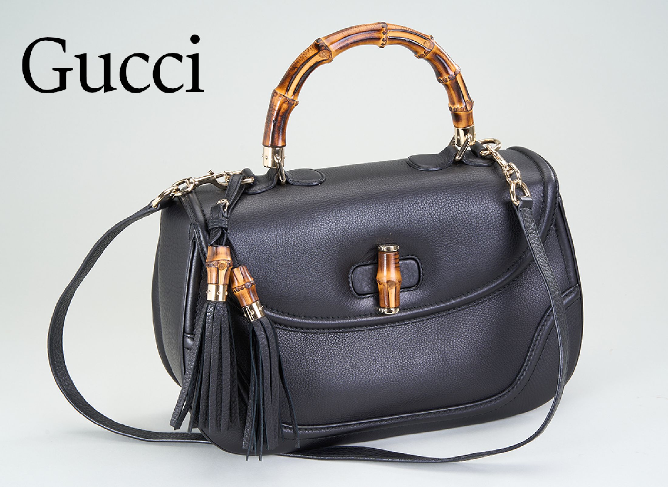GUCCI BAMBOO 1947 Handtasche, schwarzes genarbtes Leder, mit umlaufender Ziernaht, Griff, Verschluß und Quastenoberteile in Bambus, Zierringe Metall ...