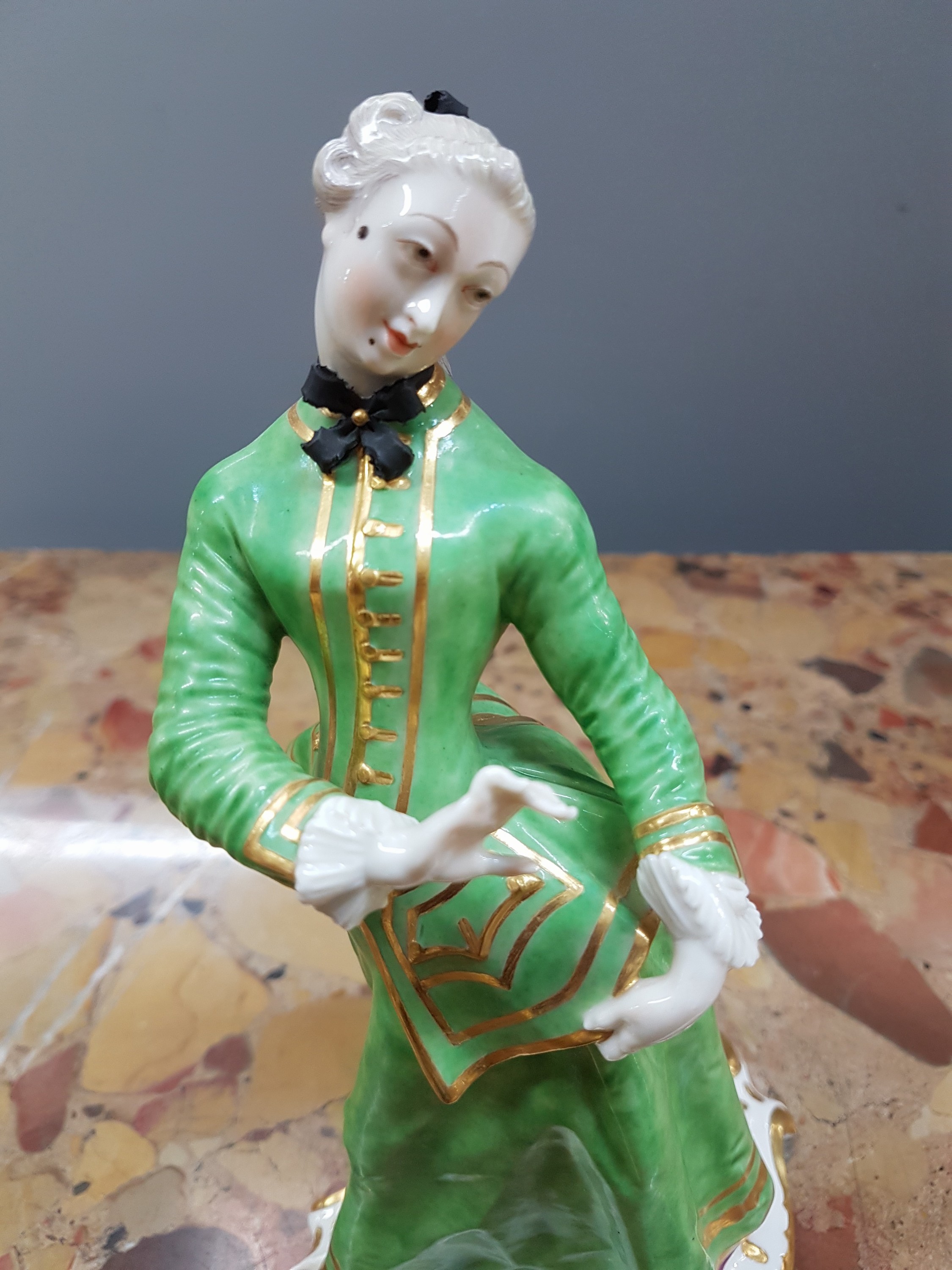 Detail e: Porzellanfigur, Nymphenburg, 20. Jh., Isabella aus der Commedia dell'Arte von Franz Anton Bustelli, bunt bemalt, reiche Goldstaffage, H. ca. 21cm