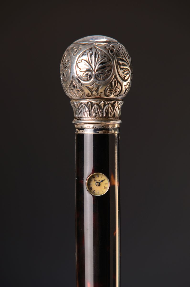 Detail a: Systemstock mit Uhr, Frankreich, um 1900, Holzschuß, Silberknauf gemarkt, floraler Reliefdekor, kleines Zifferblatt im Stock eingearbeitet, bez.: ...