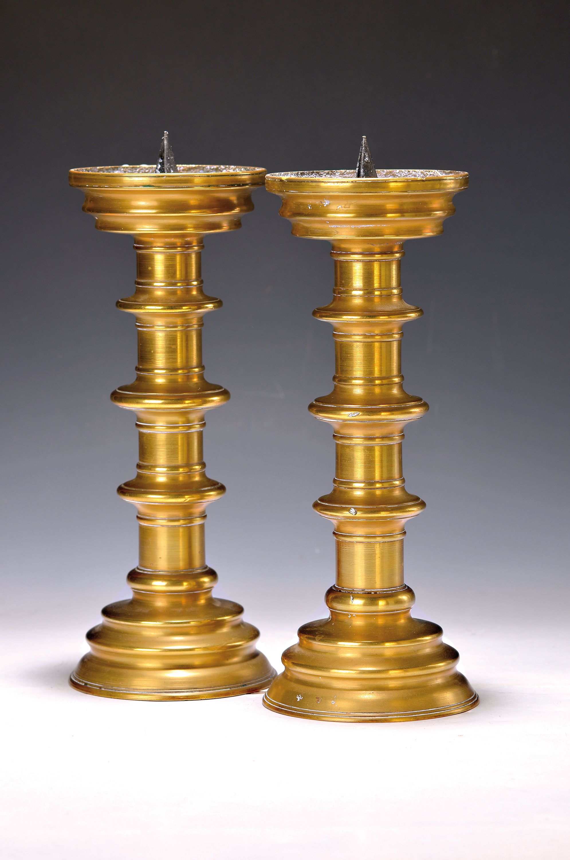 Paar Scheibenleuchter, 19.Jh., Bronze, runder gestufter Stand, Schaft mit 3 Scheiben -Nodi, Tülle mit Eisendorn, H. je. 30 cm