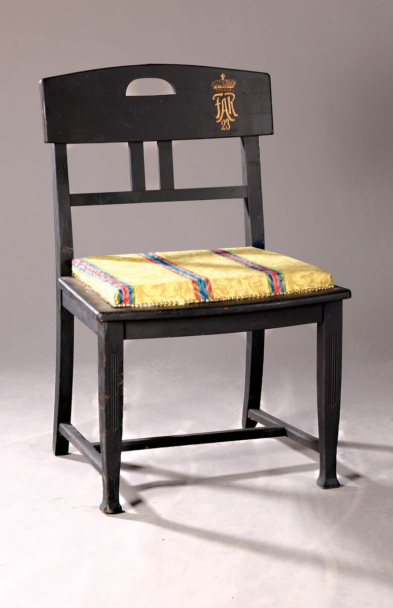 Regimentsstuhl, Feldartillerie-Regiment 23, schwarz gefaßt, Lehne Regimentszeichen, H. ca. 90cm, B. ca. 60cm, T. ca. 55 cm, gepolstert, EZ 2