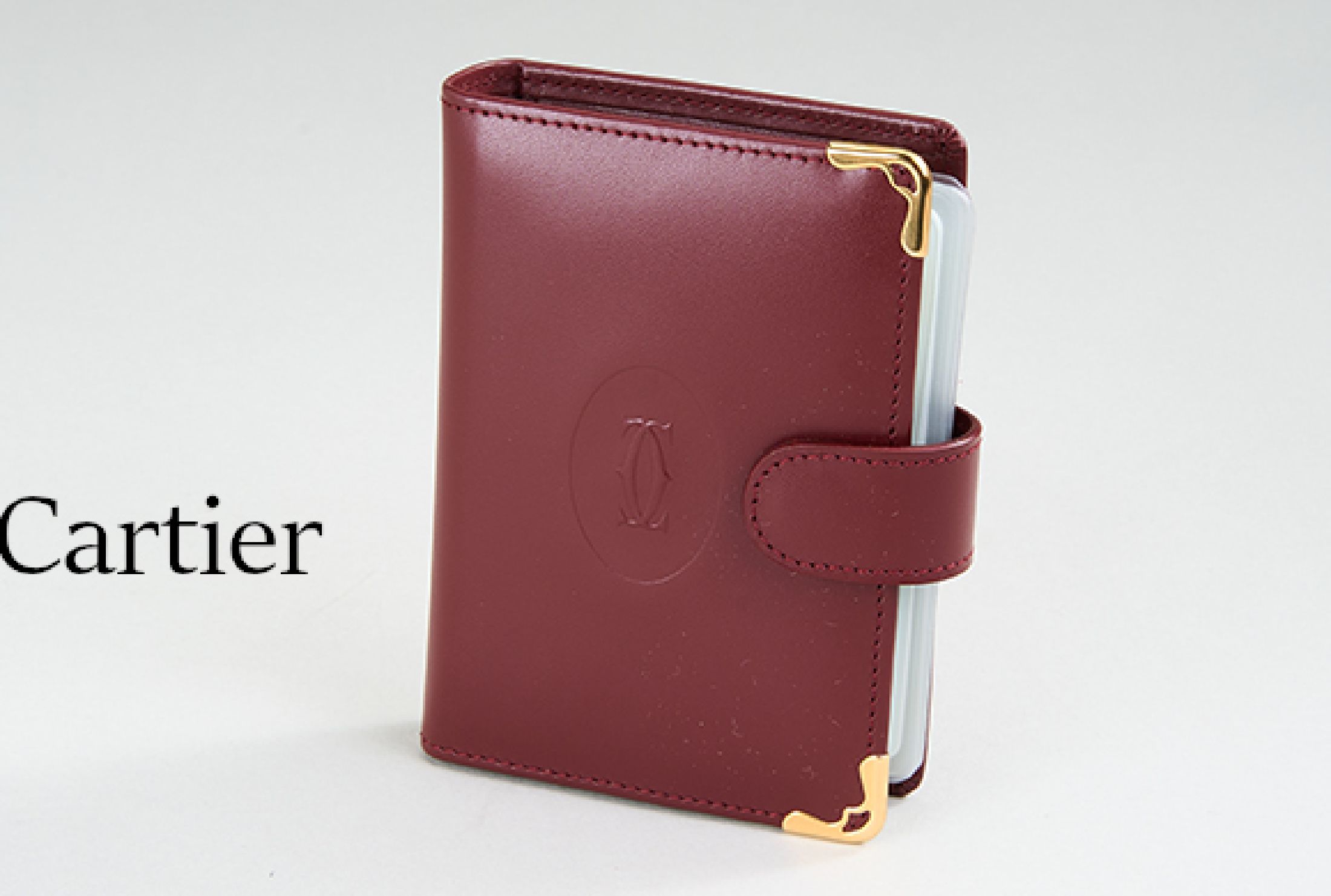 CARTIER Kartenetui, dunkelrotes Kunstleder, Monturen Metall verg., Platz für 14 Karten, in orig. Etui, guter Zustand