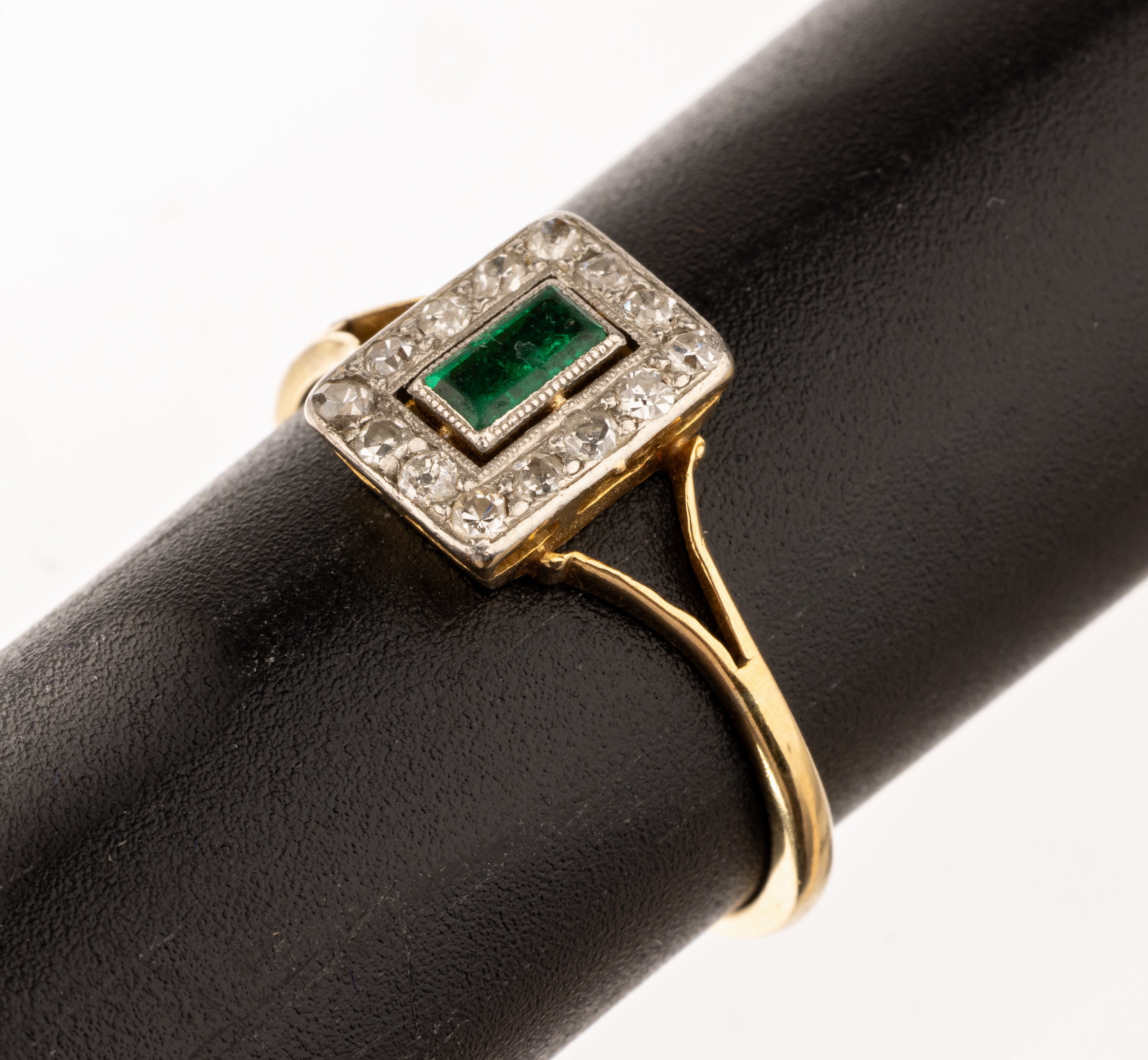 18 kt Gold Smaragd-Diamant-Ring, um 1930, GG 750/000 gepr., mittig Smaragd-Baguette ca. 0.12 ct, umgeben von 14 Altschliffdiamanten zus. ca. 0.16 ct ...