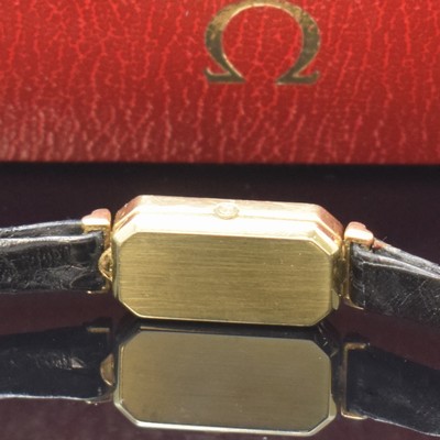 26745572b - OMEGA De Ville diamond-set 14k yellow gold ladies wristwatch, Switzerland around 1980, quartz, baguette-shaped, octagonal case, fixed lugs, stepped bezel, snap on case back, gilded dial spotty, black hands, Omega-box enclosed, measures approx. 29 x 13 mm, condition 2-3