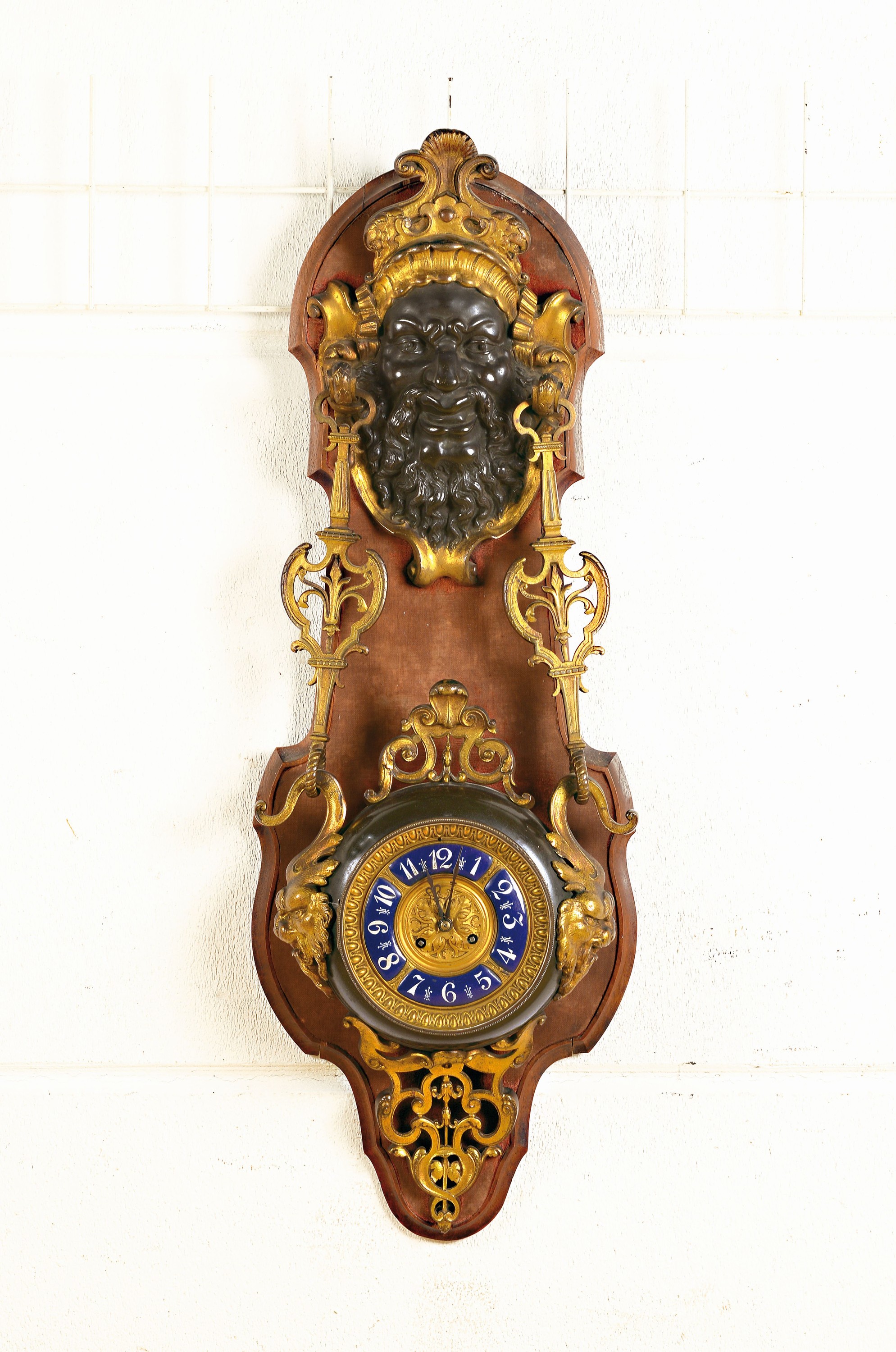 Große Wanduhr mit Maskeron, Frankreich, um 19.Jh., Holzträger mit Samtauflage (besch.), oben bekrönender bärtiger Maskeron, den Betrachter ...