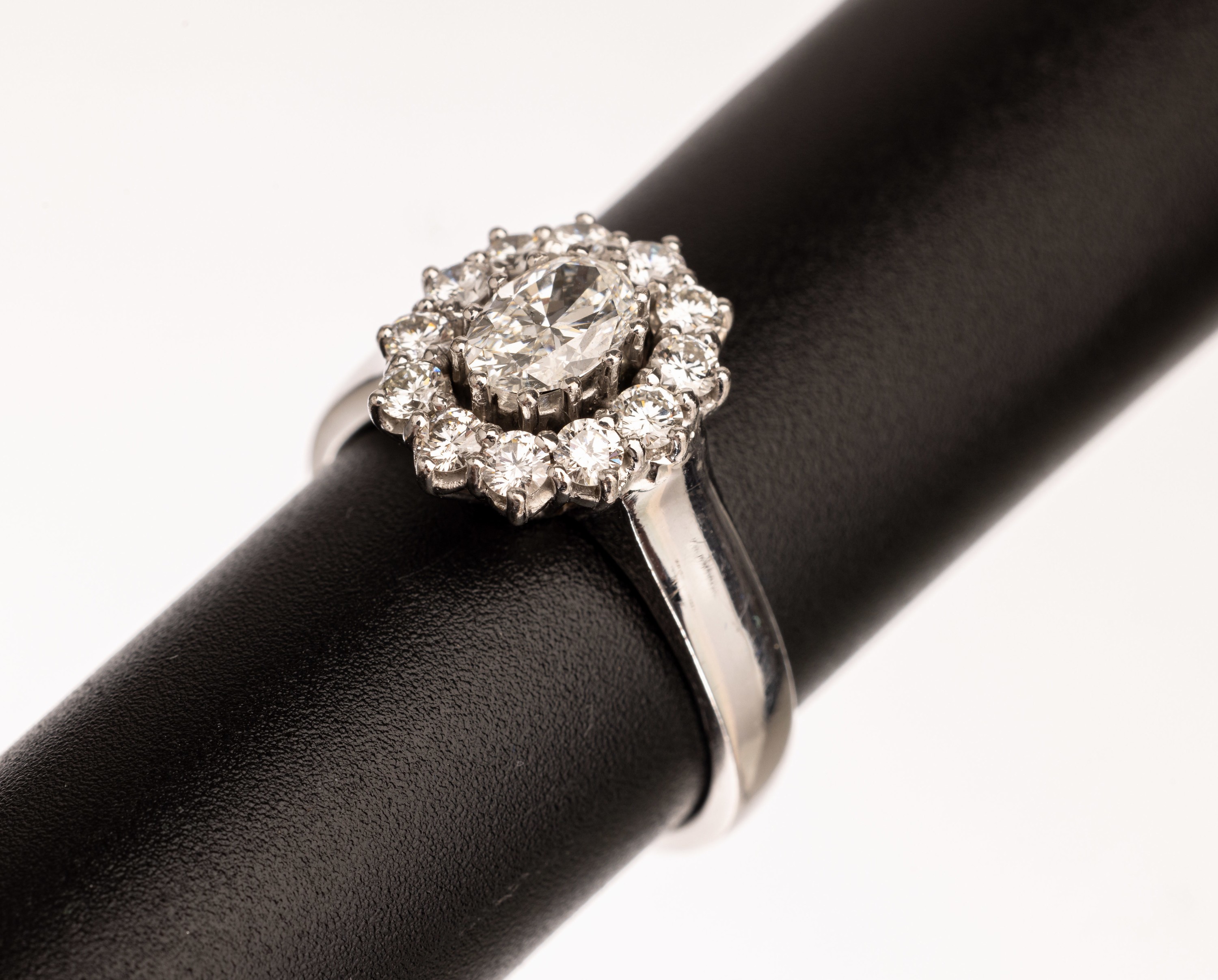 18 kt Gold Brillant-Ring, WG 750/000, blütenförm. Ringkopf, mittig ovaler Diamant ca. 1.0 ct l.get.Weiß/si, umgeben von Brillanten zus. ca. 1.0 ...