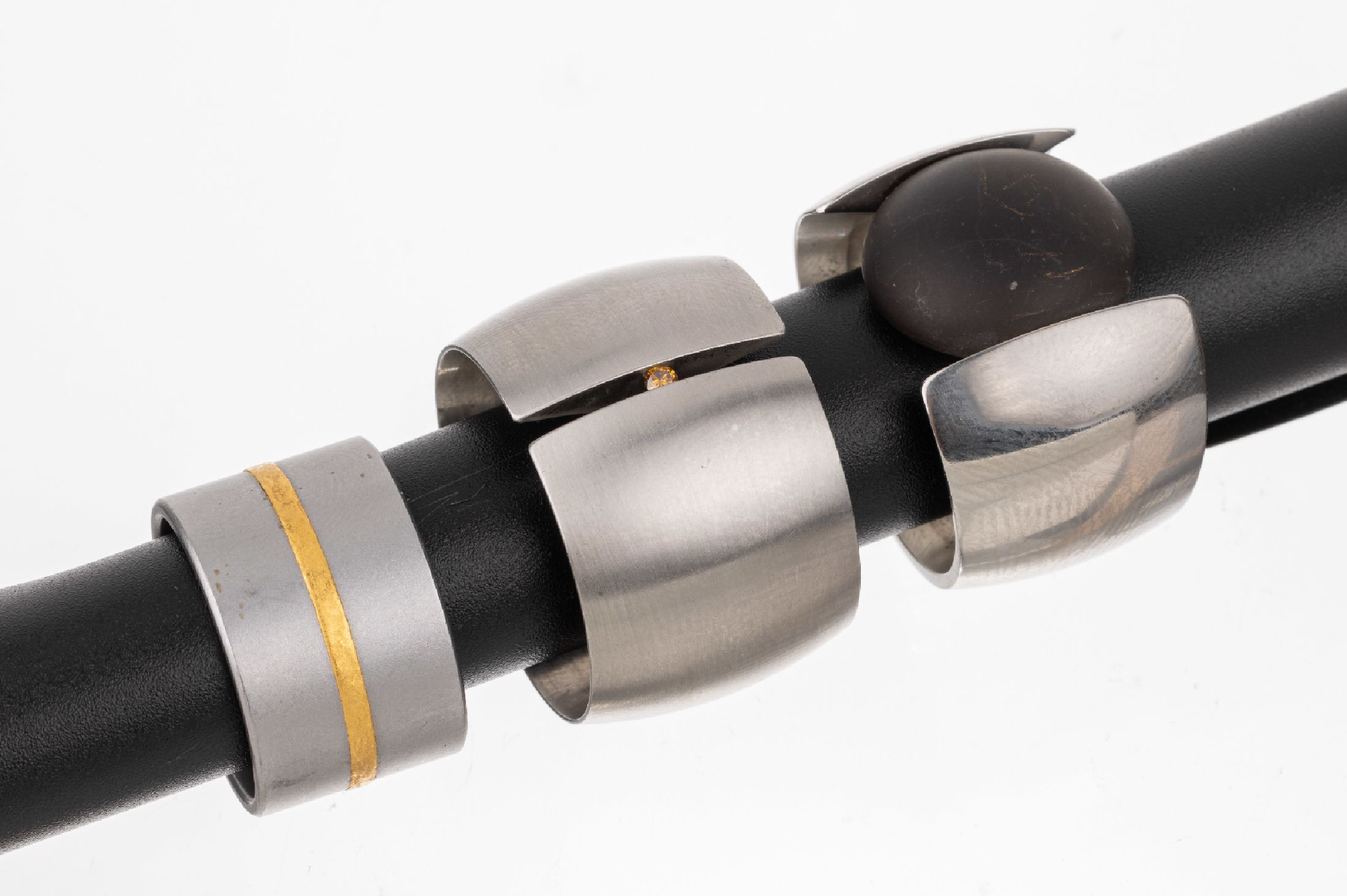 Konvolut 3 Designer Ringe, Stahl und GG 900/000, 1 x mit Brillant Braun, 1 x mit Acrylboutton, 1 x Niessing mit umlaufenden GG Streifen, RW 2 x 54, ...