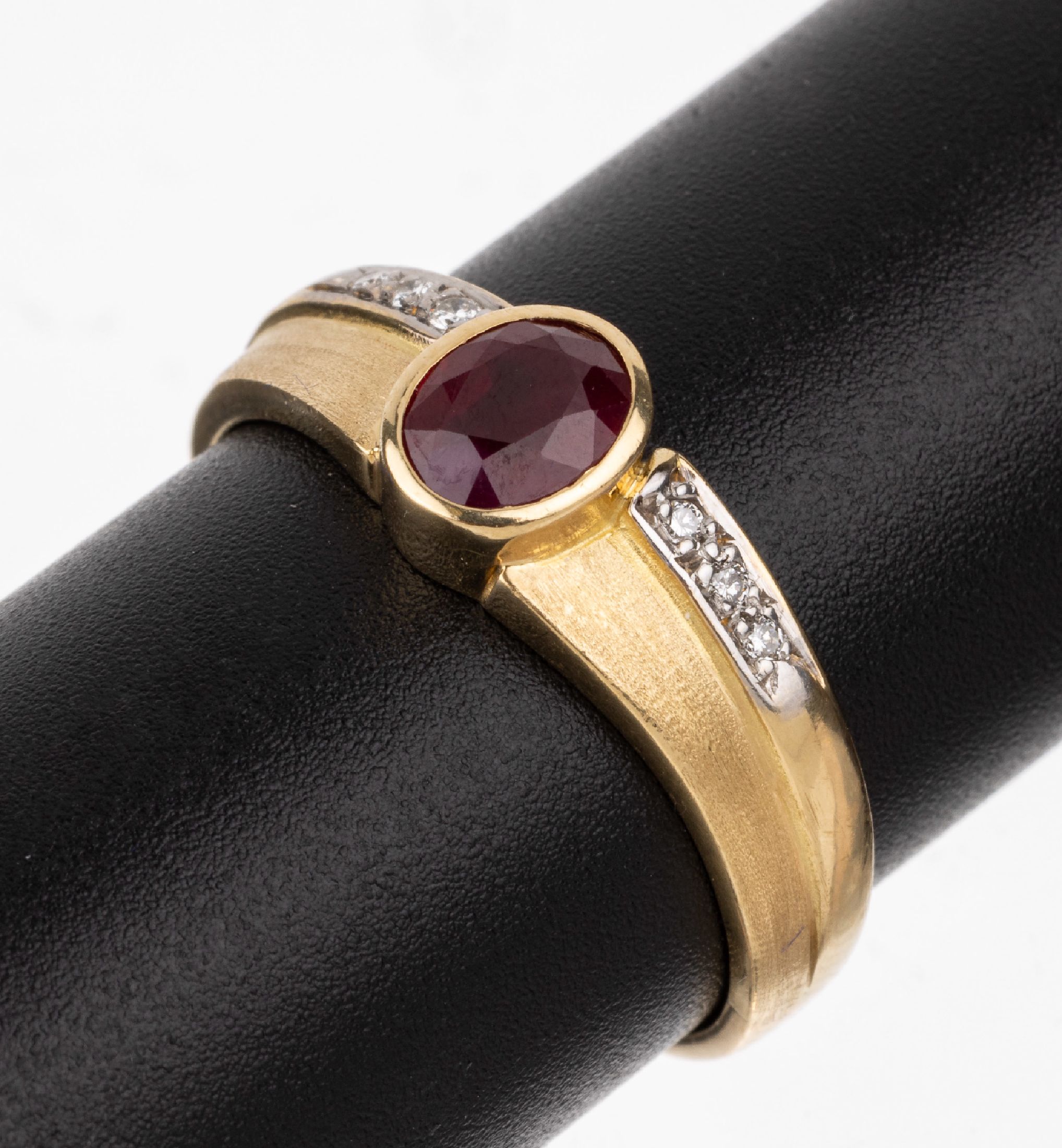 18 kt Gold Rubin-Brillant-Ring, GG/WG 750/000, mittig ovalfacett. Rubin ca. 1.06 ct,seitl. 6 in WG gefasste Brillanten zus. ca. 0.06 ct (grav.) ...