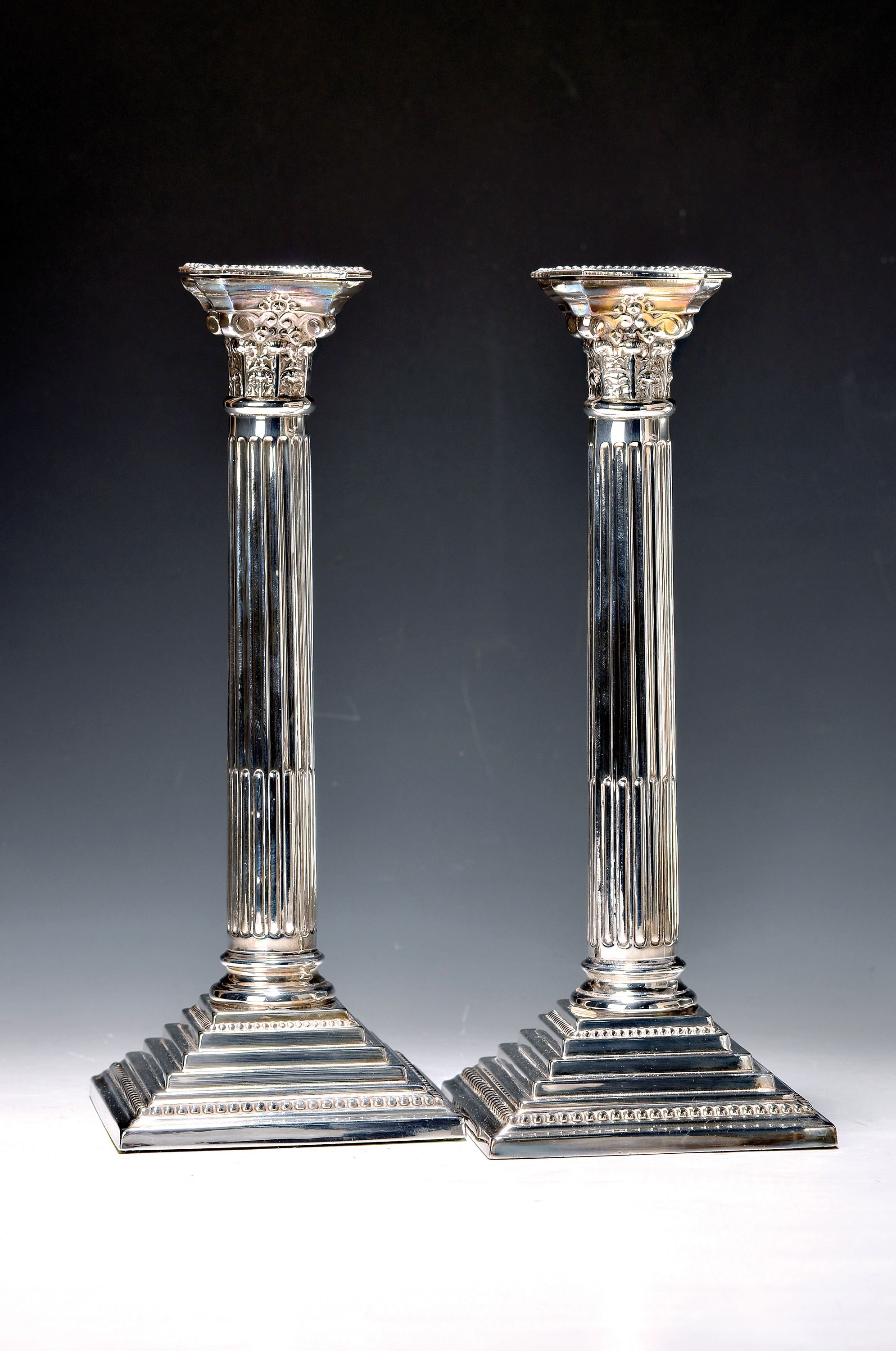 Paar Kerzenleuchter in korinthischer Säulenform, England, Sterlingsilber, gefüllt, getreppter Fuß mit Perlleisten, H. ca. 32 cm, ca. 2370 g incl. ...