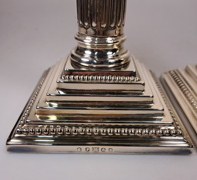 26747497c - Pair of candlesticks in Corinthian column shape, England, sterling silver, filled, stepped base with pearl strips, height approx. 32 cm, approx. 2370 g including filling, very good condition