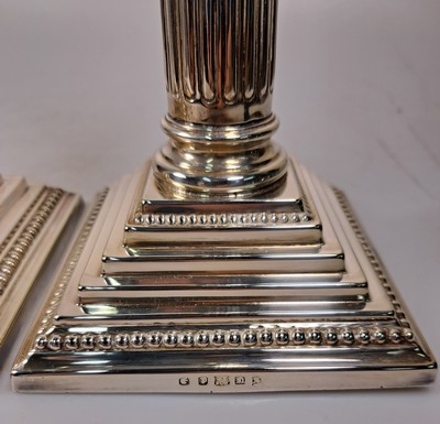 26747497d - Pair of candlesticks in Corinthian column shape, England, sterling silver, filled, stepped base with pearl strips, height approx. 32 cm, approx. 2370 g including filling, very good condition