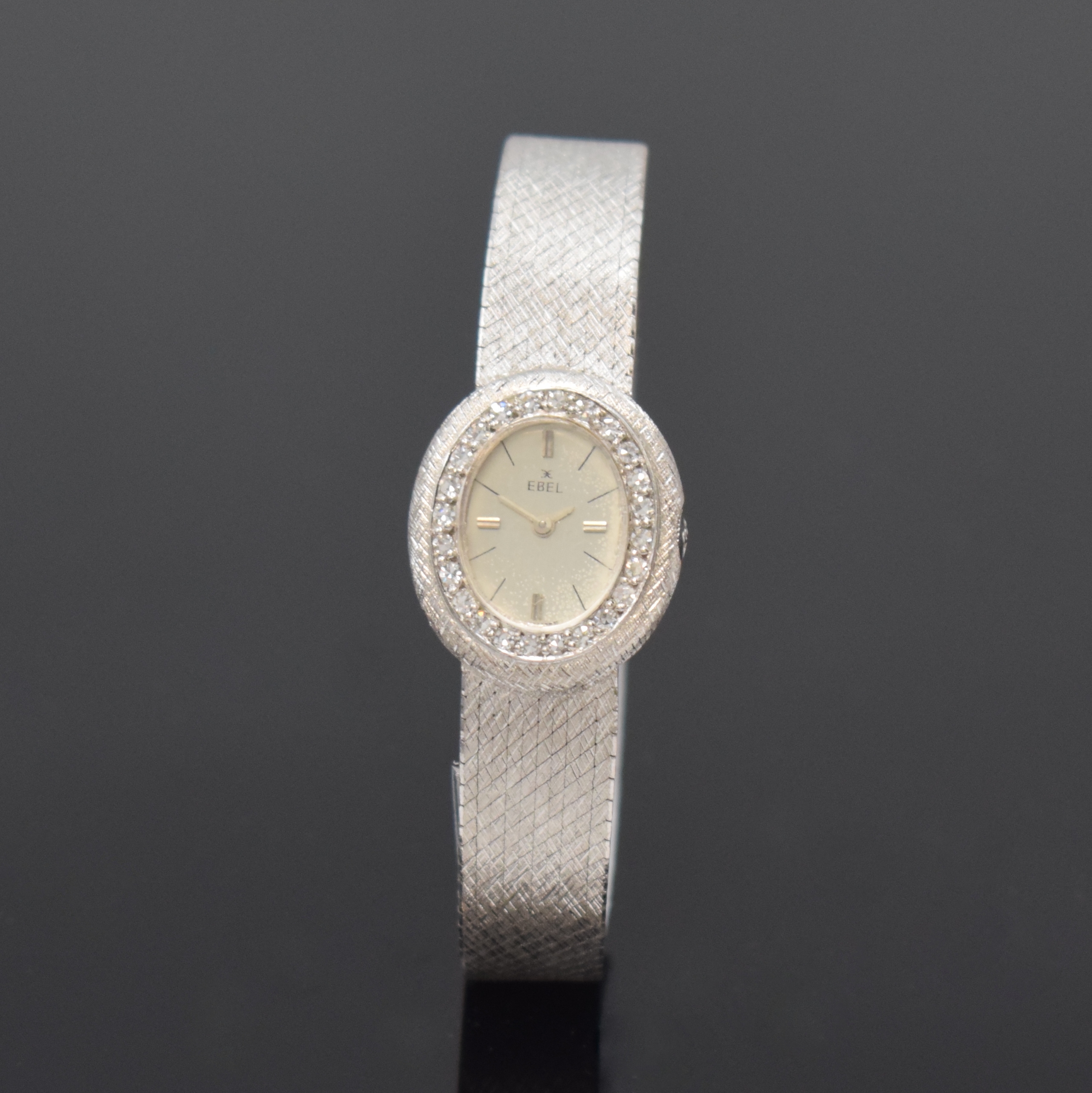 EBEL diamantbesetzte Damenarmbanduhr in WG 750/000, Schweiz um 1970, Handaufzug, unsign. 2-tlg. Geh. m. integr. Milanaiseband, Boden aufgedr., silb. ...