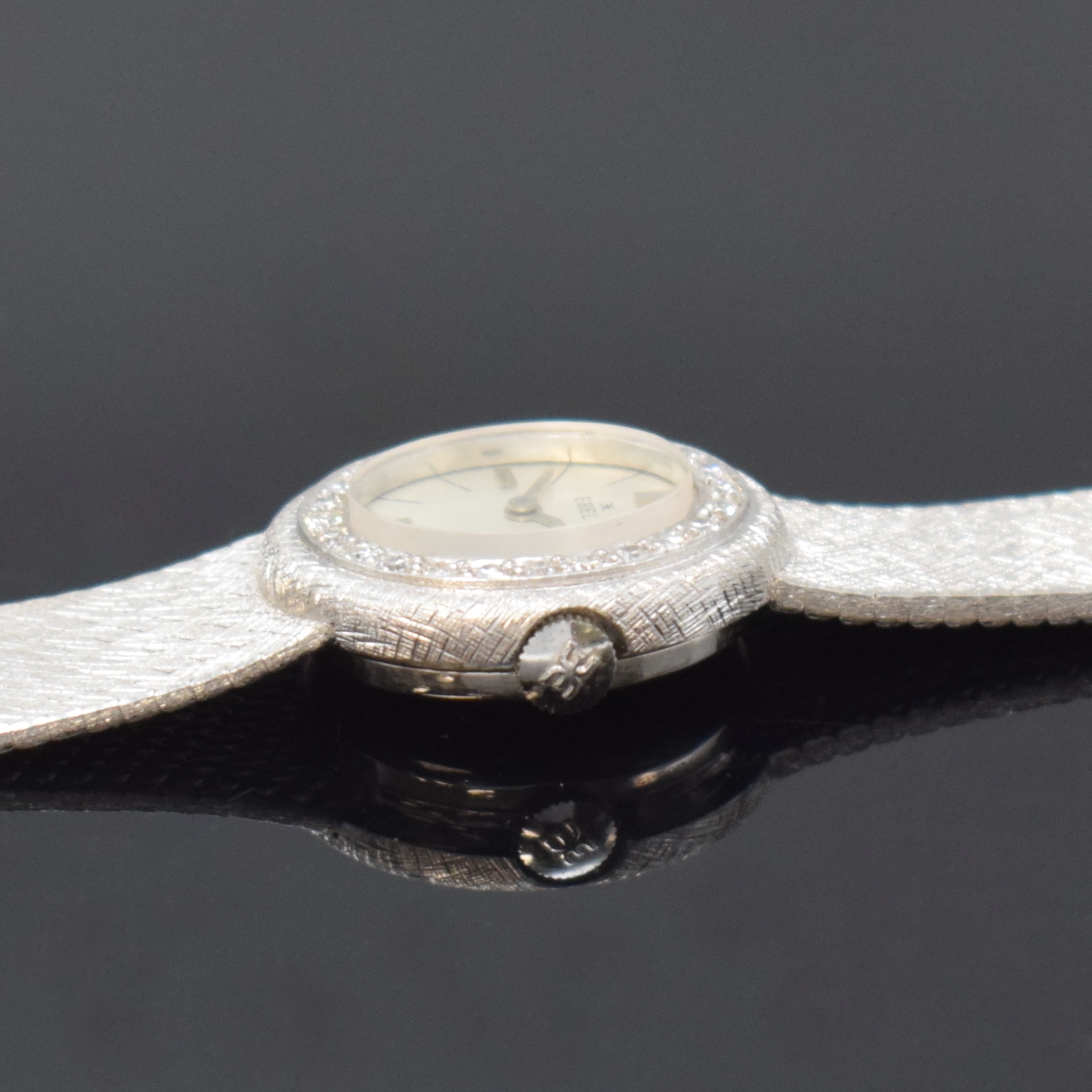Detail d: EBEL diamantbesetzte Damenarmbanduhr in WG 750/000, Schweiz um 1970, Handaufzug, unsign. 2-tlg. Geh. m. integr. Milanaiseband, Boden aufgedr., silb. ...
