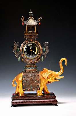 Image 26750490 - Figure clock with alarm clock, Far Eastern production around 1930/50, in the shape of a processional elephant, silver, set with turquoise and carnelian cabochons, movement and alarm clock start, glass cover, wooden base with brass thread inlays, saddle cloth and top loosened, height approx. 38cm, condition of movement 2 , housing 2-3
