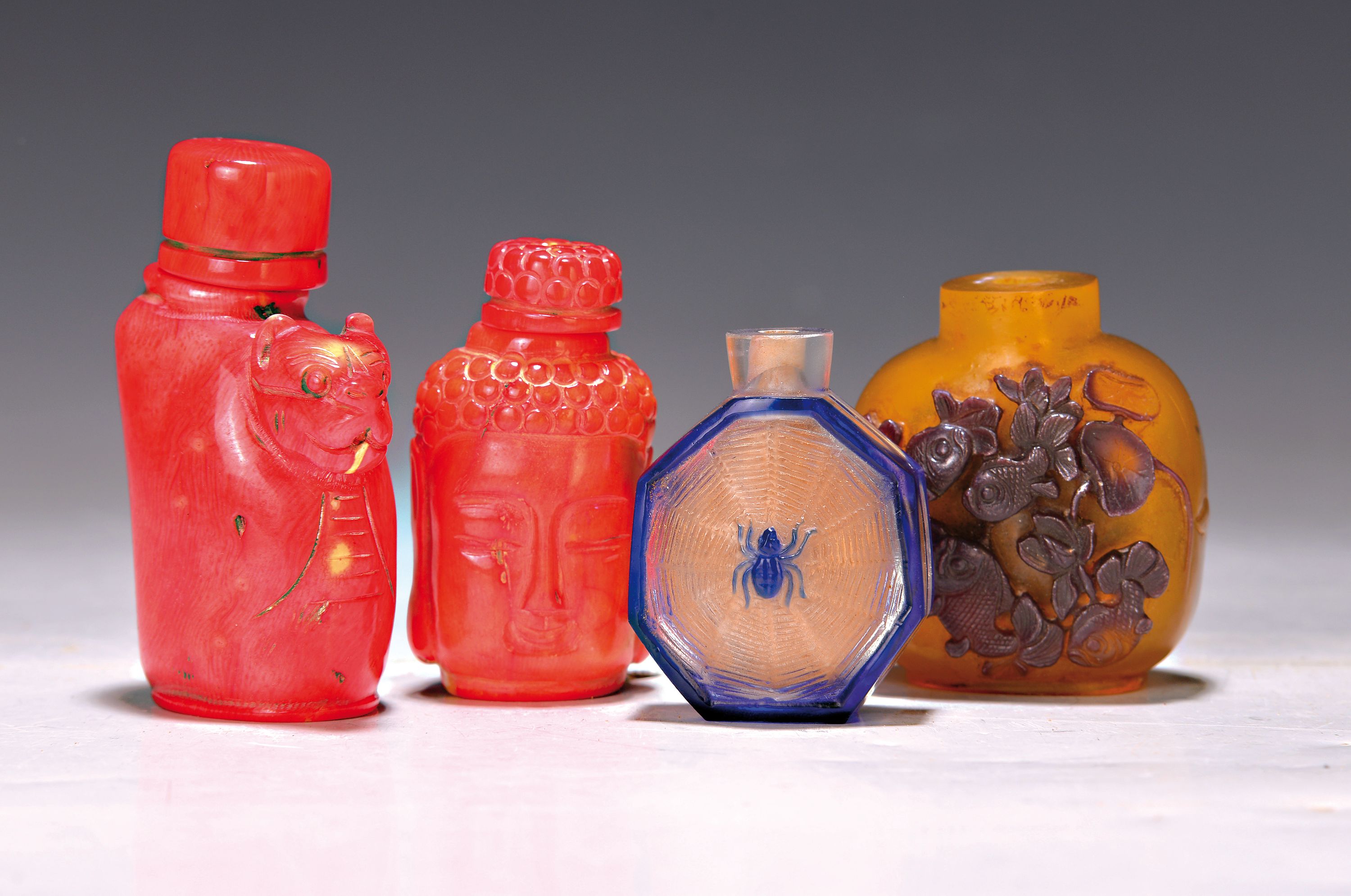 4 Snuffbottles, überwiegend China, 19./20.Jh., 2 Glas Fläschchen ohne Stöpsel, geätzter bzw. geschnitzter Reliefdekor: Spinneim Netz bzw. Fische ...