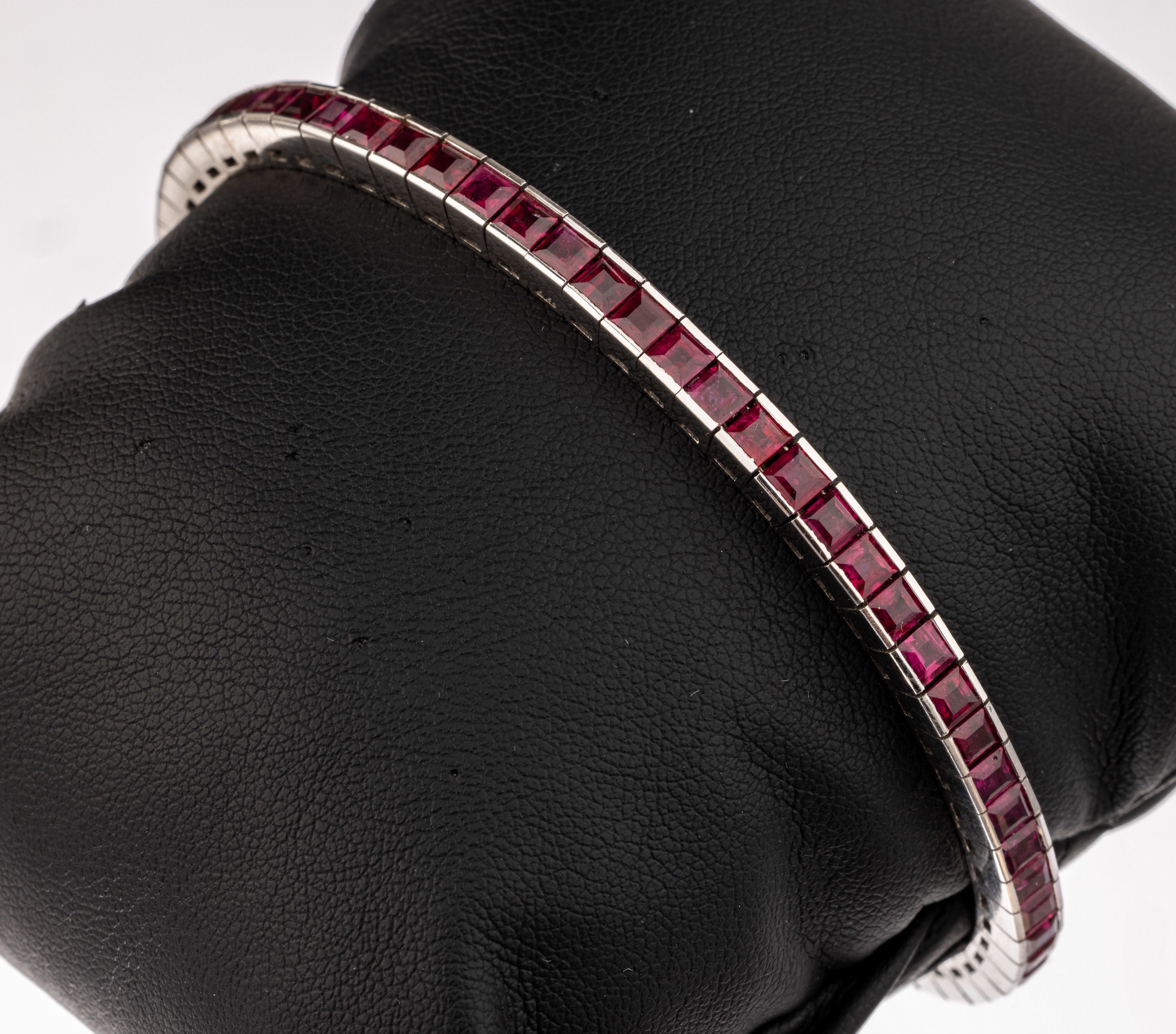 18 kt Gold Rubin-Armband, WG 750/000, 65 Rubin-Carrees (inkl. Verlängerungsstück) zus. ca. 6.80 ct, L ca. 18.5 cm, Verlängerungsstückca. 2 cm, ...