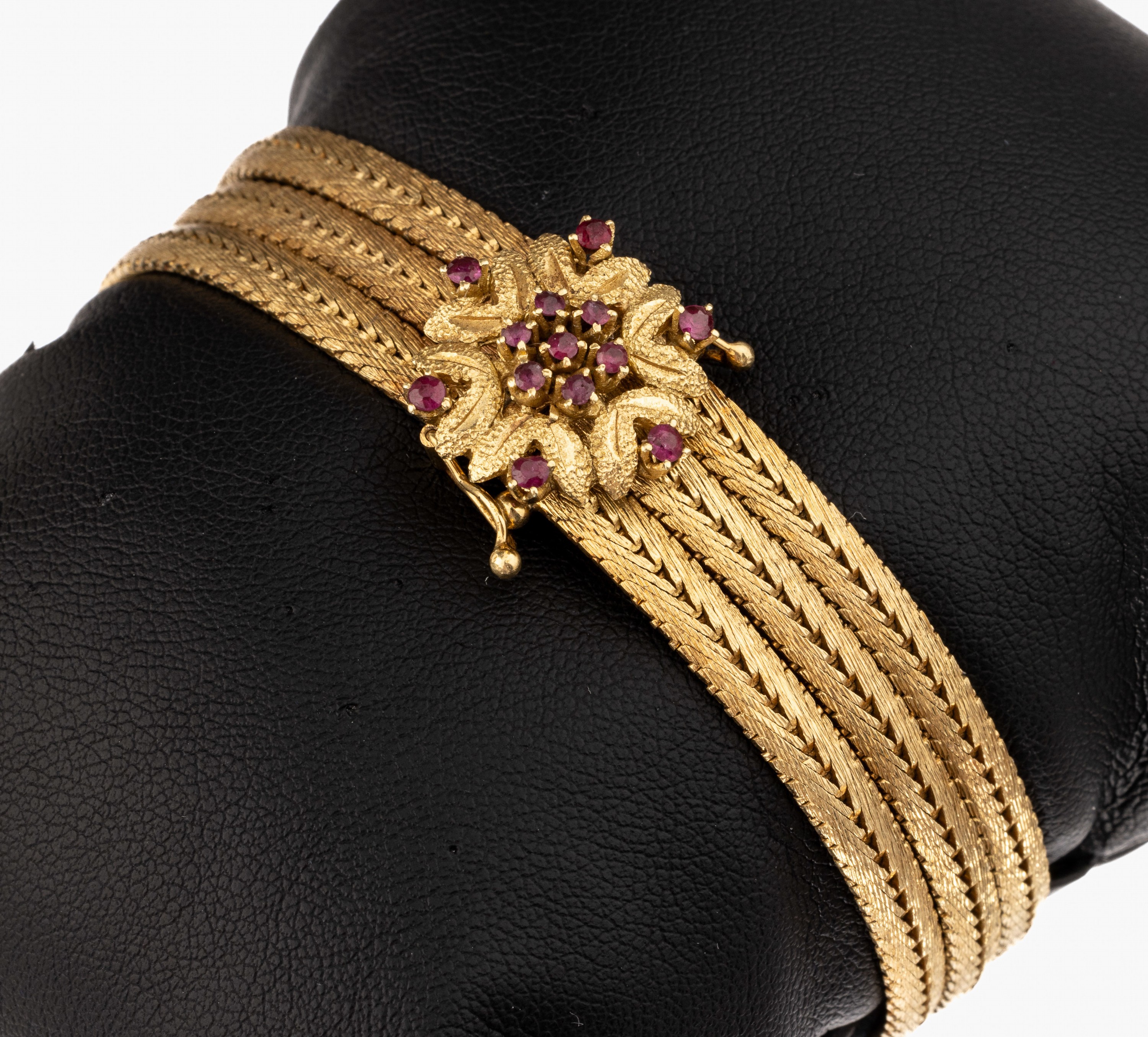 14 kt Gold Rubin-Armband, GG 585/000, 3 rhg., Kastenschloss blütenf. mit kl. rundfacett. Rubinen, L. ca. 19 cm, 2 Sicherheitsachten, ca. 41.7 g