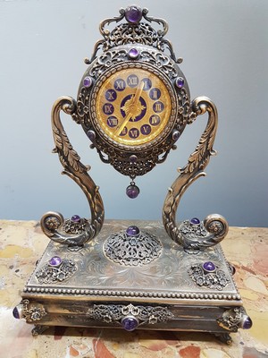 26755226a - Table clock, USA, around 1960/70, based on an antique model, 925 sterling silver housing, inscribed Sander, base all around with pearl strip decoration, profiled, decorated feet, clock is held by large volute struts, glass stones, gold-plated dial, back cover, movement cover decorated, anchor escapement, does not tarnish, with certificate, H. approx. 25cm, condition of work 3-4, housing 3