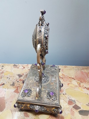 26755226e - Table clock, USA, around 1960/70, based on an antique model, 925 sterling silver housing, inscribed Sander, base all around with pearl strip decoration, profiled, decorated feet, clock is held by large volute struts, glass stones, gold-plated dial, back cover, movement cover decorated, anchor escapement, does not tarnish, with certificate, H. approx. 25cm, condition of work 3-4, housing 3