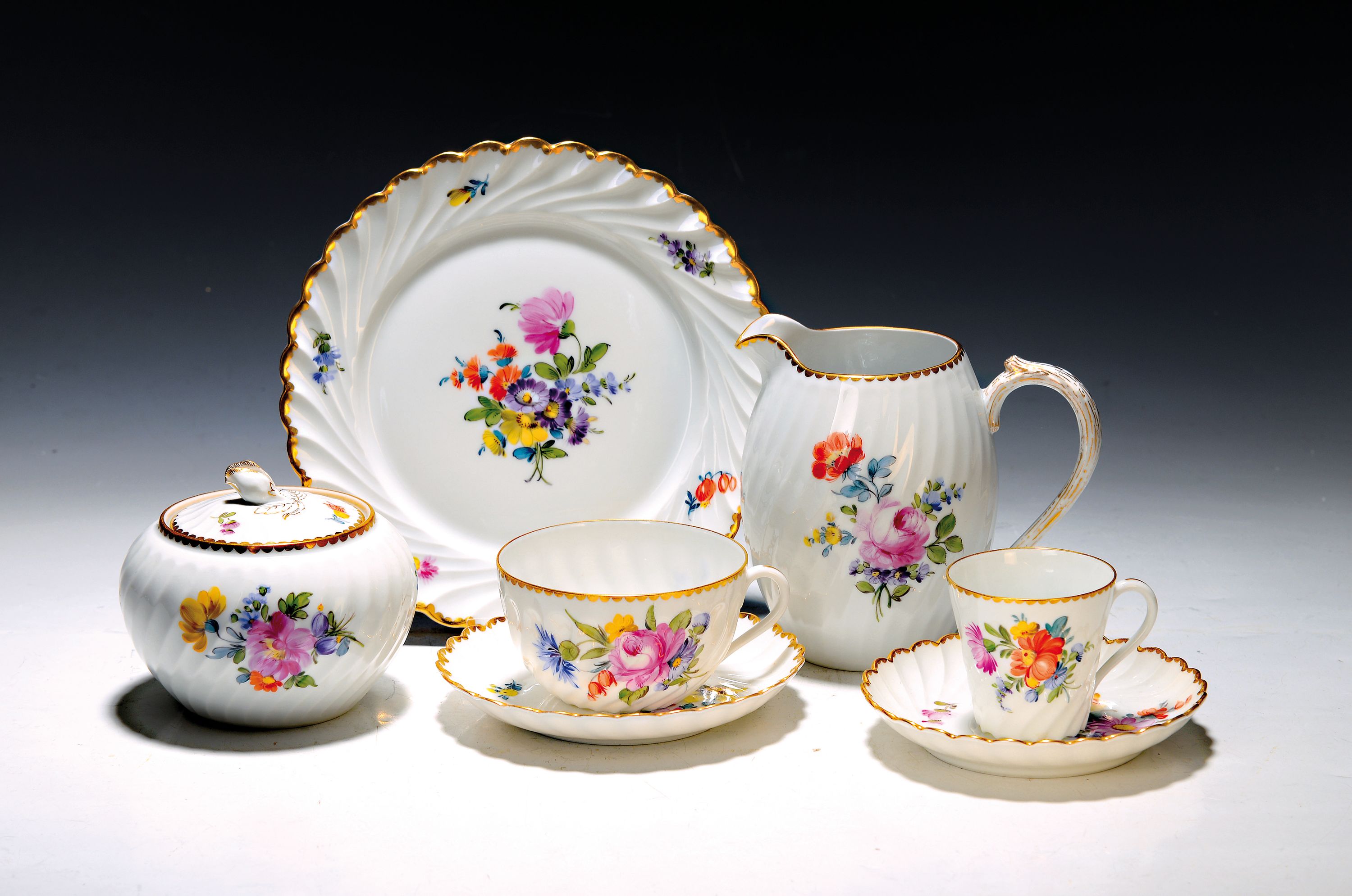 Heißgetränkeservice, Nymphenburg, Wellenform gerippt, 20.Jh., Porzellan, handbemalter Dekor aus Streublumen und Blumenbuketts, Goldrand, 3 ...