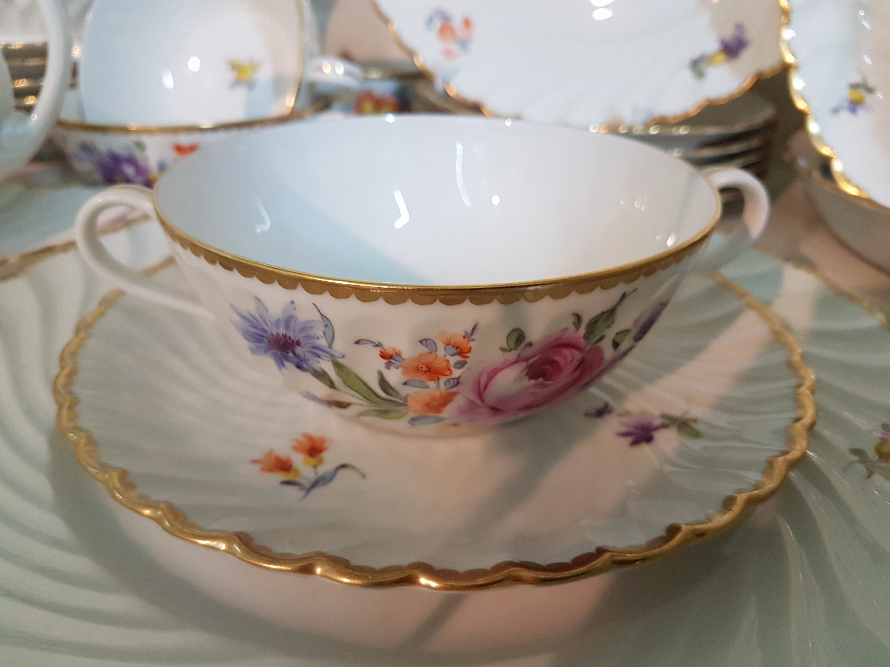 Detail d: Speiseservice, Nymphenburg, Wellenform gerippt 20.Jh., Porzellan, handbemalter Dekor aus Streublumen und Blumenbuketts, Goldrand, 8 Suppentassen mit ...