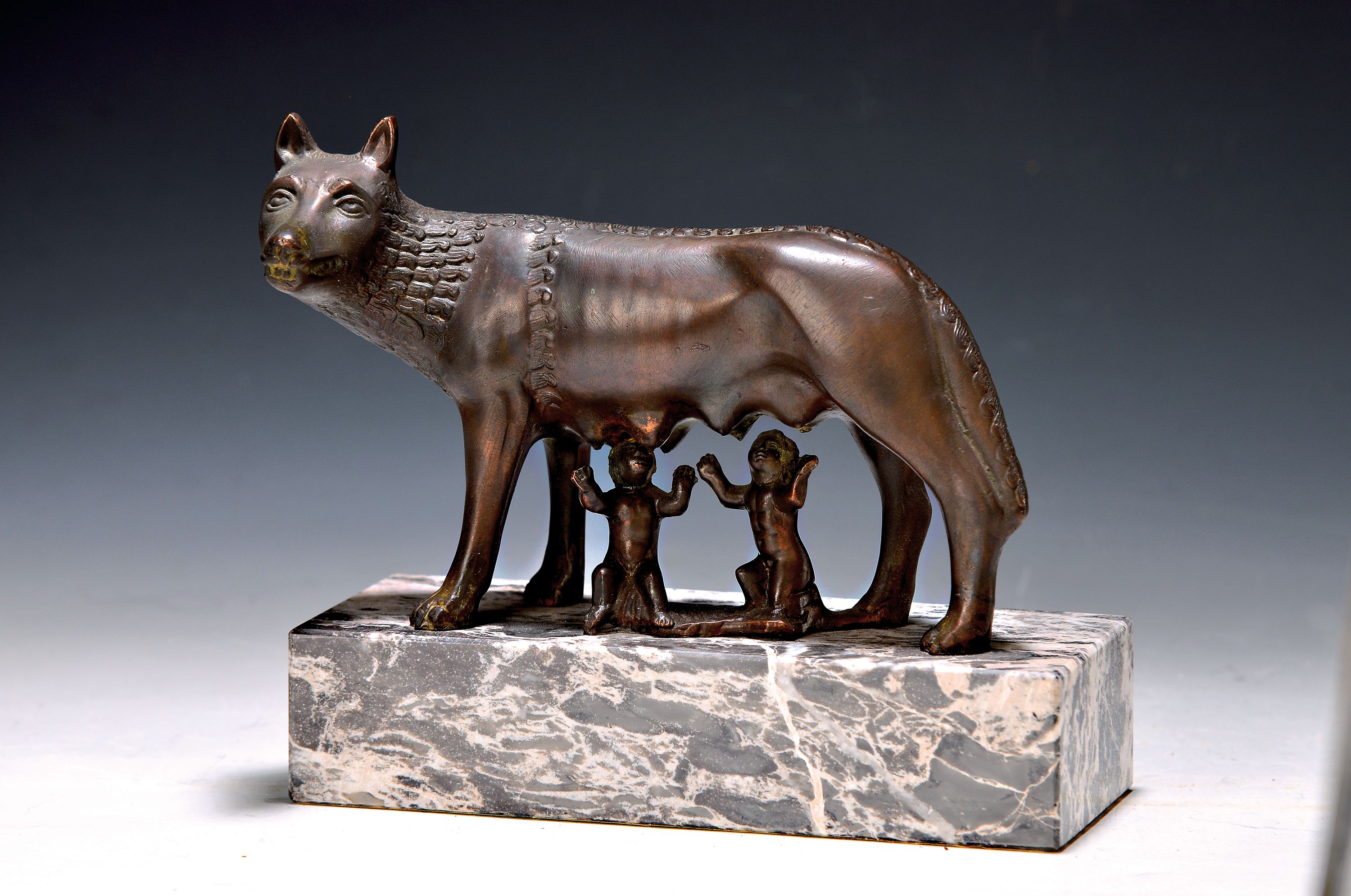 Bronzefigur "kapitolinische Wölfin", 20. Jh., wohl Italien, die Wölfin säugt Romulus und Remus, ca. 16 x 18 x 7 cm, Marmorsockel