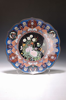 Image 26760815 - Large cloisonne plate, Japan, 2nd half of the 19th century, around 1900, blue ground, colorful floral decoration in the middle on copper powdering in the so-called tea- goldstone technique, surrounding borders with elaborately designed fields, diameter approx. 45 cm, the underside is slightly damaged due to age