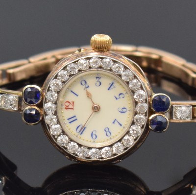 26760995a - LE ROY very rare early high-grade diamond-set wristwatch in 15k pink gold, France around 1910, smooth hinge case, hinged gold-cuvette marked" To the Queen Le Roys & Fils , 57 New Bond Street, London, Paris, Made in France", original patinated heavy strap with sapphires (approx. 1,6 ct) and old cut-diamonds (white/p approx. 2,7 ct.), frame-enamel dial, blue Arabic numerals with red 12, gilded spade hands, gold-plated precision movement, end stone on escape wheel, compensation-balance, diameter approx. 25 mm, weight approx. 35g, condition 2 extraordinary in this quality and version