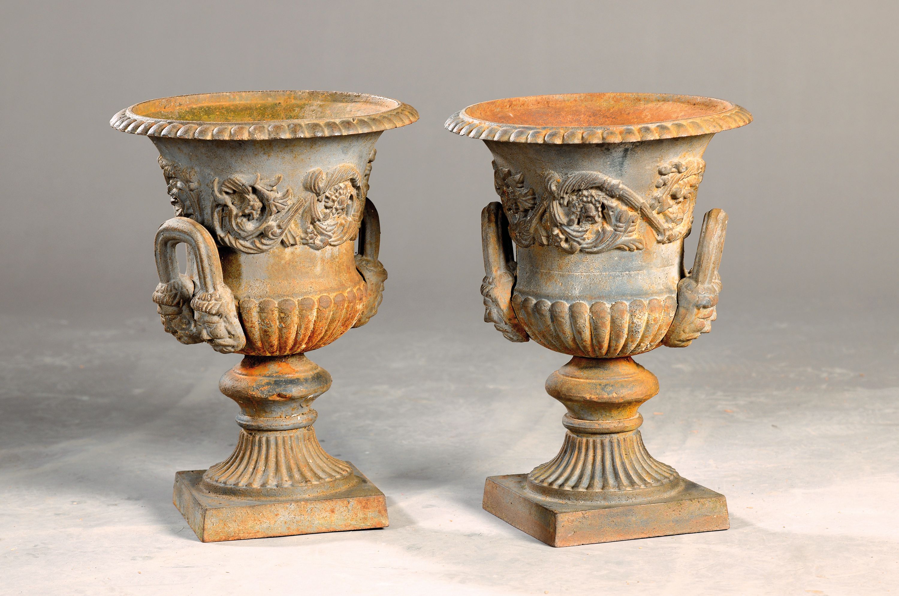 Paar Kratervasen, Frankreich, 2. Hälfte 19. Jh., Eisenguß, reich reliefiert, Henkel mit Maskeronen, bewittert, H. ca. 38cm