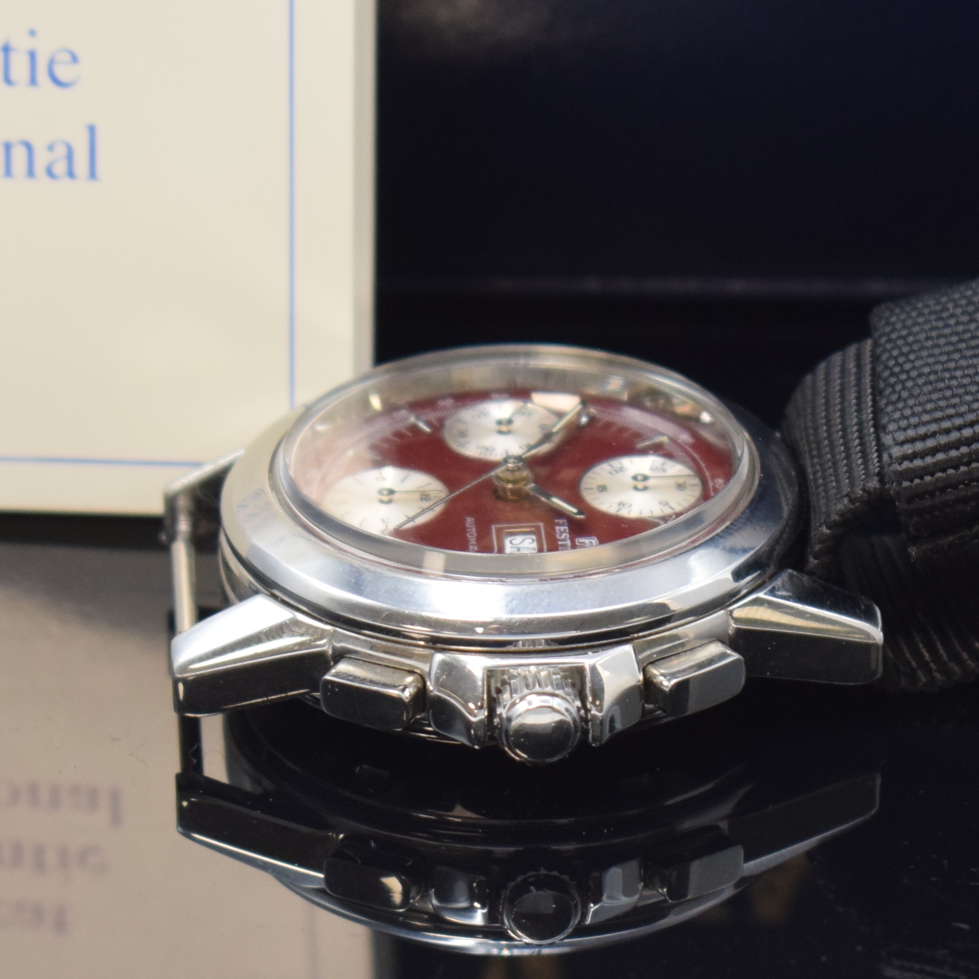 Detail b: FESTINA Armbandchronograph in Stahl, Schweiz verk. lt. beil. Pap. 08/1993, Automatik, Boden u. Krone verschr., rotes Zifferbl., silb. Hilfsblätter, ...
