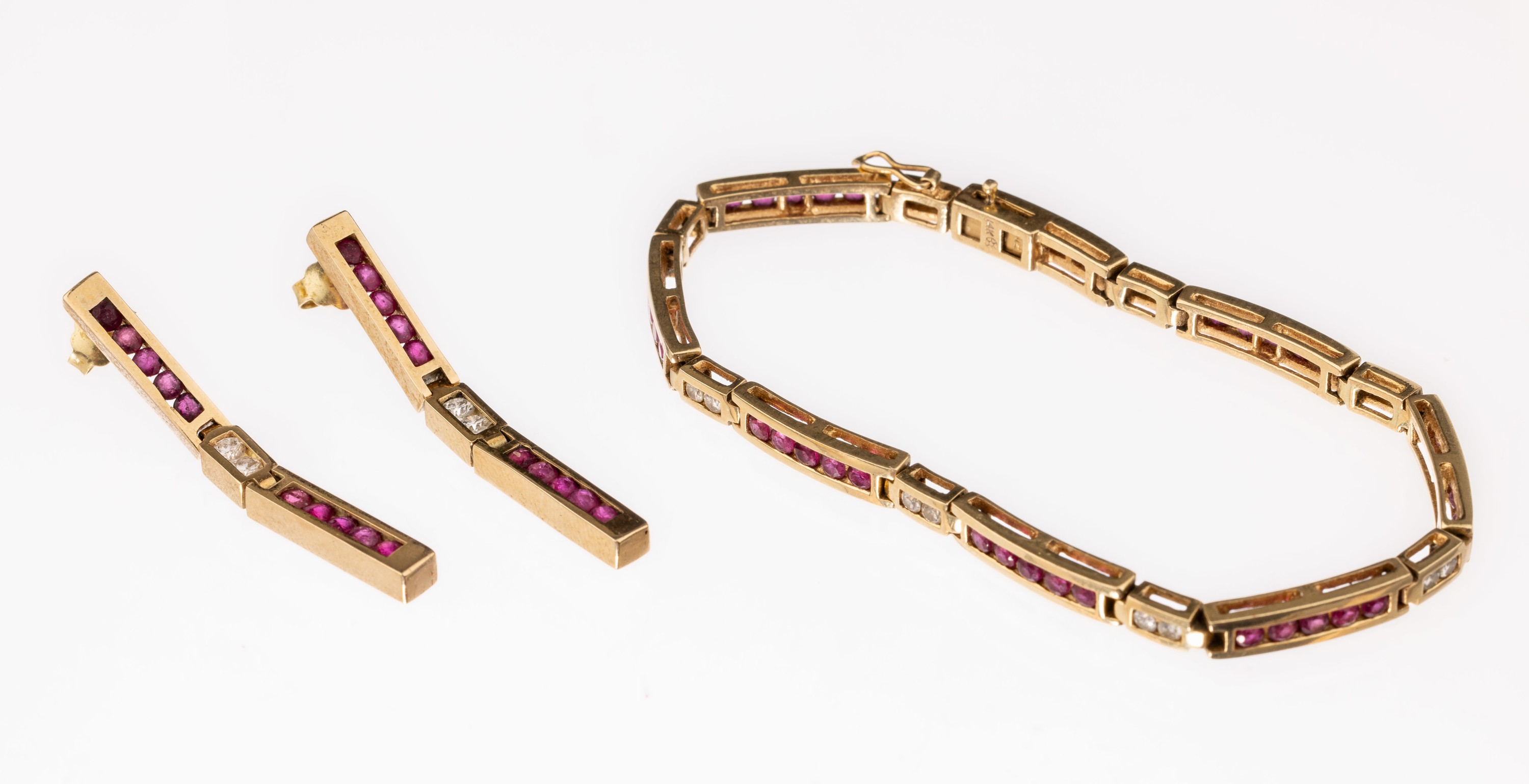 14 kt Gold Rubin-Brillant-Schmuckset, GG 585/000, best. aus: 1 Armband und Paar Ohrstecker, 20 Brillanten zus. ca. 0.68 ct Weiß/si, 60 rundfacett. ...