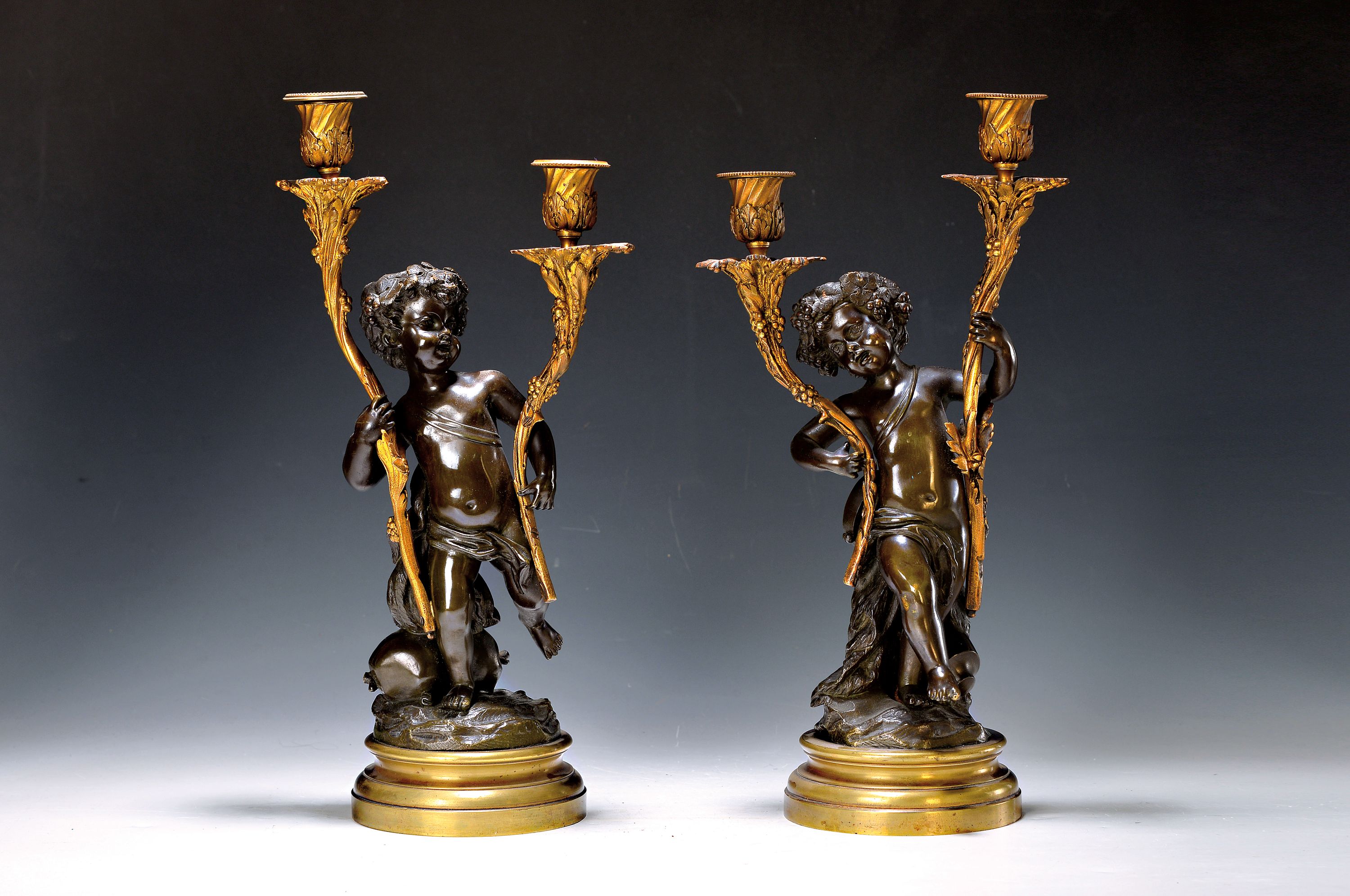 Paar Kerzenleuchter, Frankreich, 2. Hälfte 19.Jh., nach Clodion (1738-1814), Bronzeguß, vollplastische Amoretten mit Zweigen, die die Kerzen ...