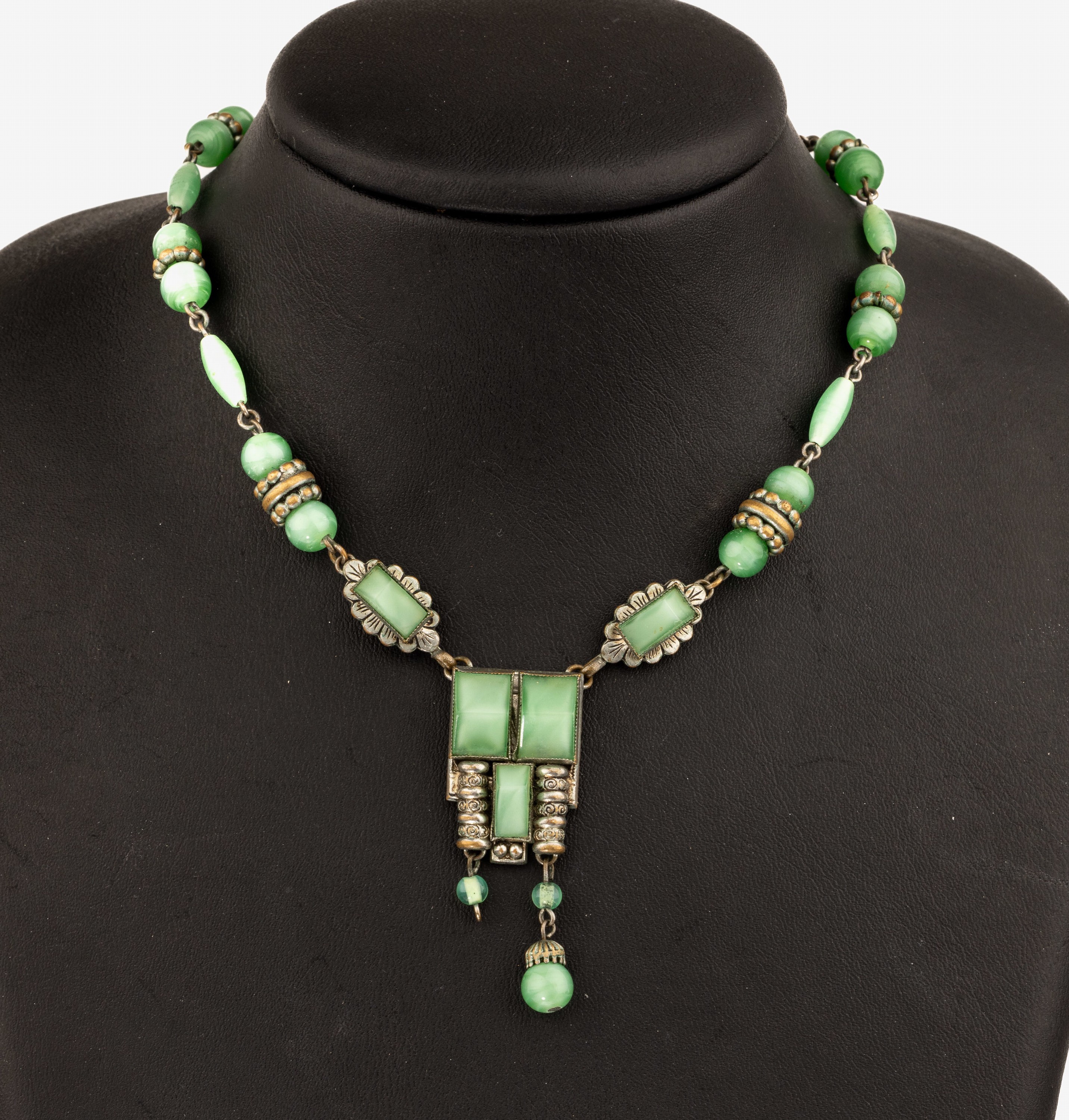 Art-Deco Collier, um 1925, wohl Österreich,Metall versilbert, z.T. berieben, grünlich marmorierter Glasbesatz, Mittelteil mit bewegl. Abhängung, ...