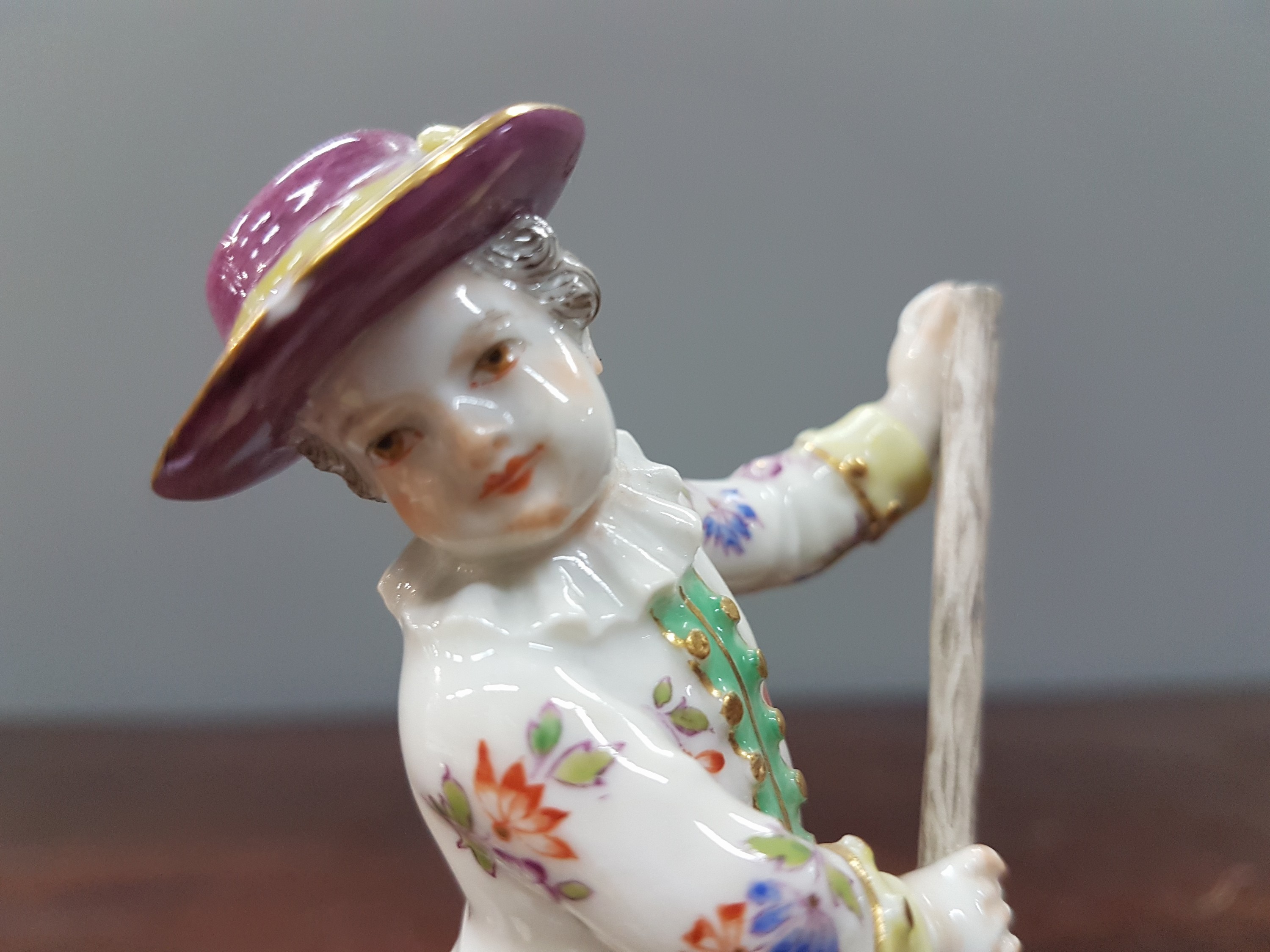 Detail e: Porzellanfigur, Meissen, Anfang 20. Jh., am Stab und am Hut l. best., Porzellan, bunt bemalt, Goldstaffage, H. ca. 11.5 cm
