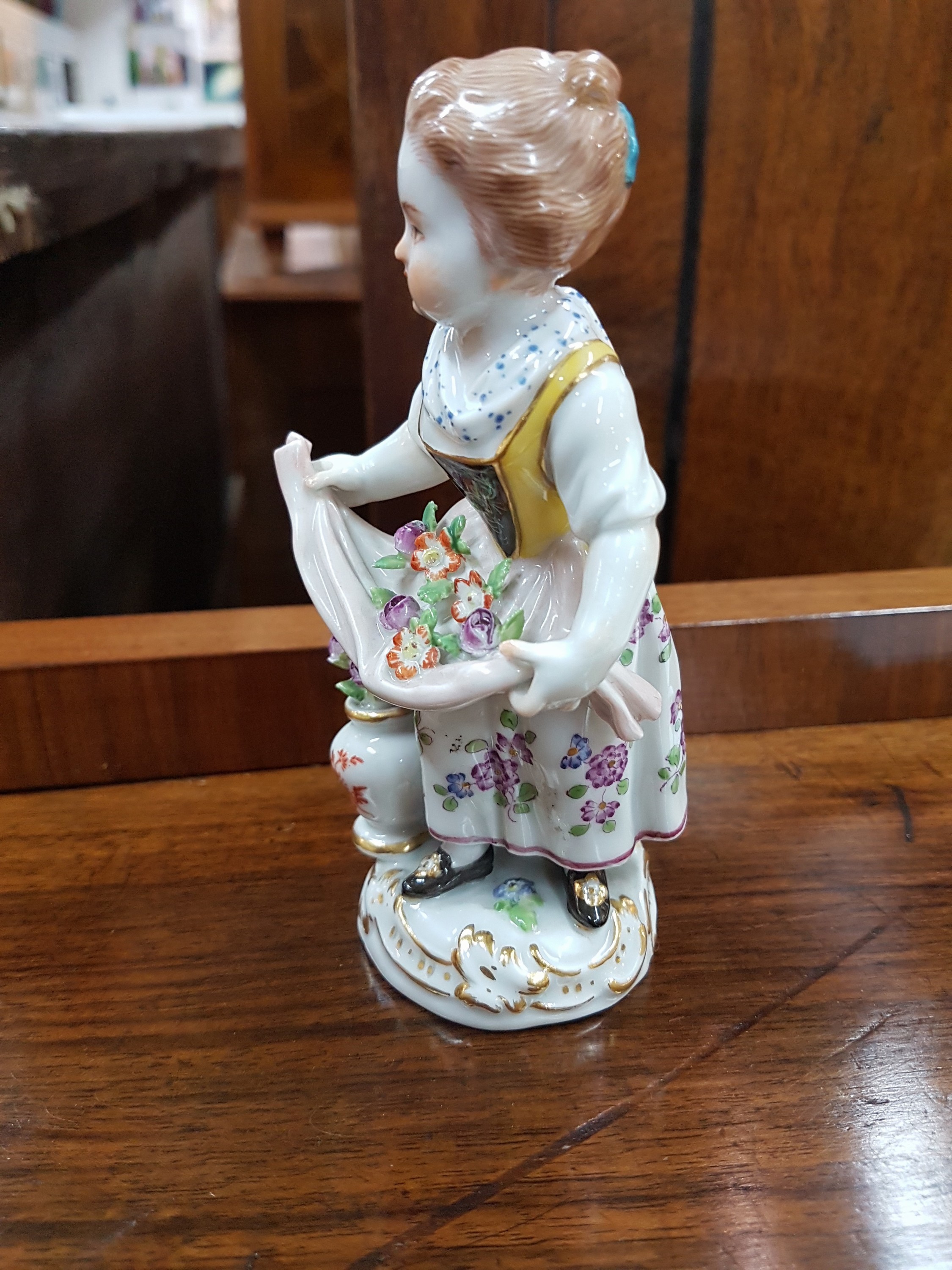 Detail b: Porzellanfigur, Meissen, 20. Jh., Gärtnerin mit Blumenvase, min. an den Blümchen rest. bzw. best., polychrom bemalt, H. ca. 12.5 cm