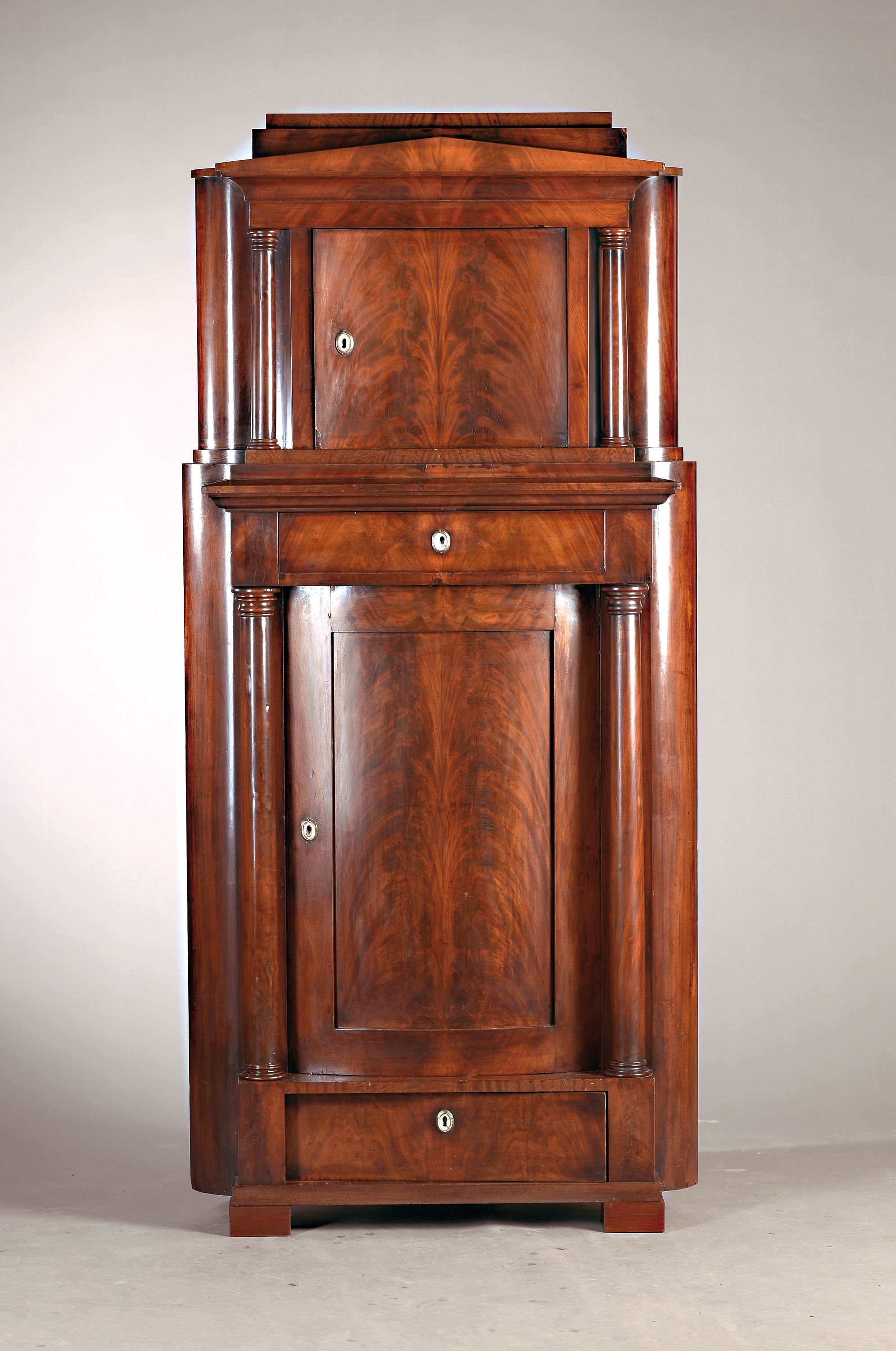 Säulenschrank mit Aufsatz, norddeutsch, um 1820/25, Mahagonifurnier, Unterteil eine Tür und 2 Schubladen, flankiert von 2 Vollsäulen, Aufsatz ...