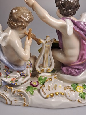 26765618k - Porcelain group, Meissen, around 1890/1900, allegory of poetry, designed by Johann Joachim Kaendler, two musical cupids, model no. 2464, fine polychrome painting, gold decoration, pommel swords, approx. 12.5 x 16 cm