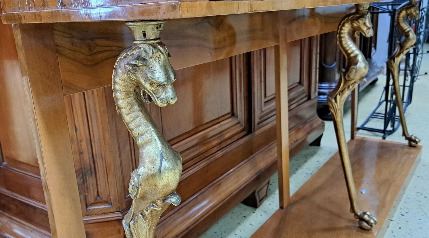 Detail c: Konsole/Anrichte, im Biedermeier-Stil, um 1900, Nußbaumfurnier, 4 Schubladen, Korpus wird getragen von vergoldeten fabelwesenartigen Seepferdchen, ...