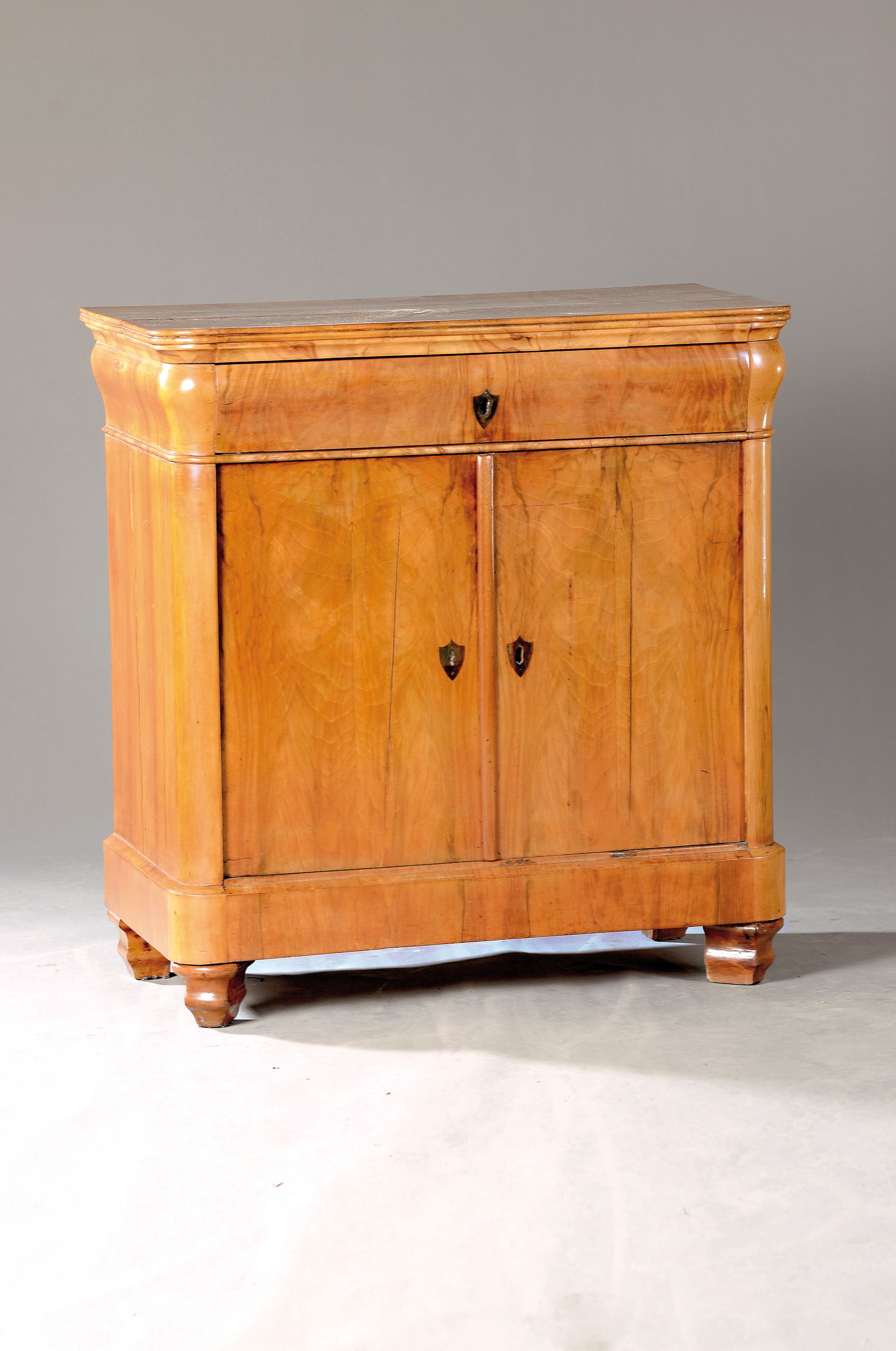 Biedermeier-Kommode, um 1830, Nußbaumfurnier, zweitürig, geschwärzte Schlüsselbuchsen, eine Schublade, ca. 89 x 84 x 45 cm, EZ 2-3
