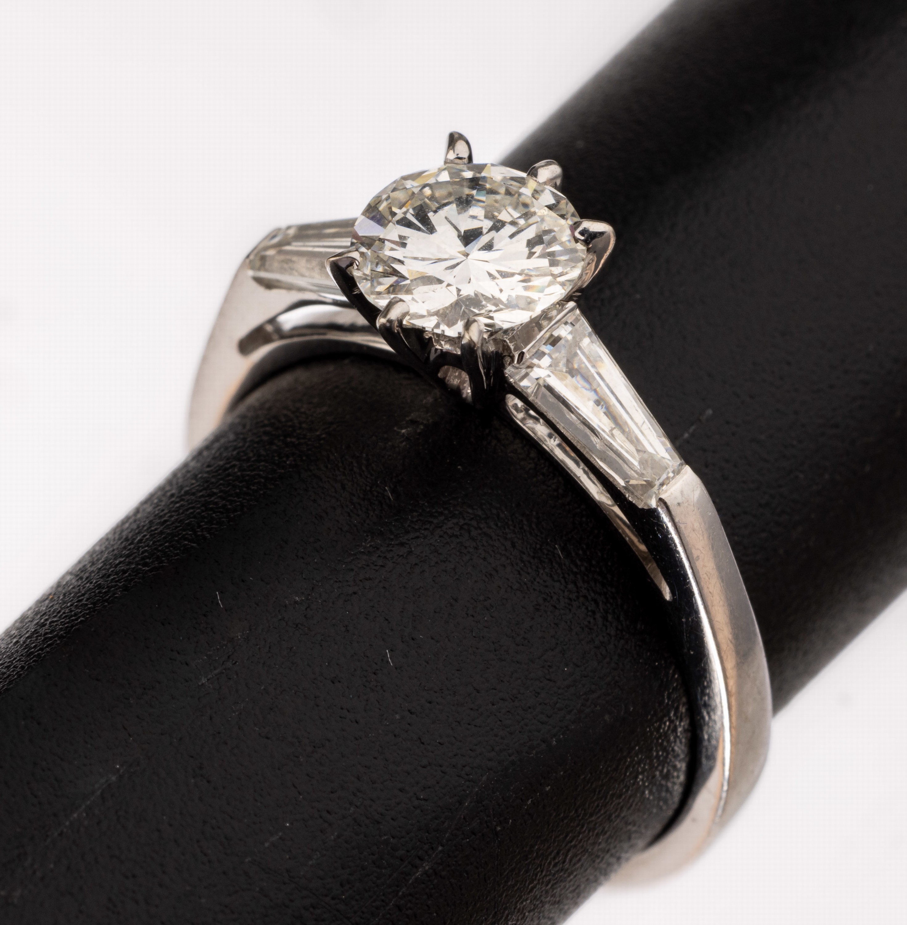 18 kt Gold Diamant-Ring, WG 750/000, mittig Brillant ca. 0.67 ct Weiß/vs-si, seitl. 2 Diamant-Trapeze zus. ca. 0.35 ct Weiß/lr-vs, RW 50, ca. 2.9 g