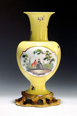 Image 26768015 - Yellow background decorative vase, Meissen, 18th century, porcelain, yellow background, pair of picture cartouches with fine painting: Watteau scene on the front, flower bouquet on the back, scattered flowers, painting probably Isaac Jacob Clauce, a jour worked bronze foot with asymmetrical shell work, on the side of the foot marked, gold decoration, h. 32.5 cm, slightly rest.
