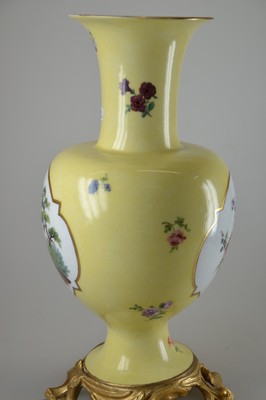 26768015f - Yellow background decorative vase, Meissen, 18th century, porcelain, yellow background, pair of picture cartouches with fine painting: Watteau scene on the front, flower bouquet on the back, scattered flowers, painting probably Isaac Jacob Clauce, a jour worked bronze foot with asymmetrical shell work, on the side of the foot marked, gold decoration, h. 32.5 cm, slightly rest.