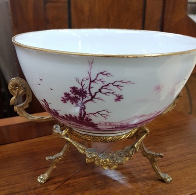 26768048c - Magnificent bowl on a bronze stand, Meissen, painting probably Bonaventura Gottlieb Häuer, around 1745/50, porcelain, camaieu painting in purple, pastoral landscape all around, inside base with picture cartouche, masterly depth perspective, gold edges, gold-plated bronze fittings, mouth edge restored, D. 15.5 cm, slight traces of age