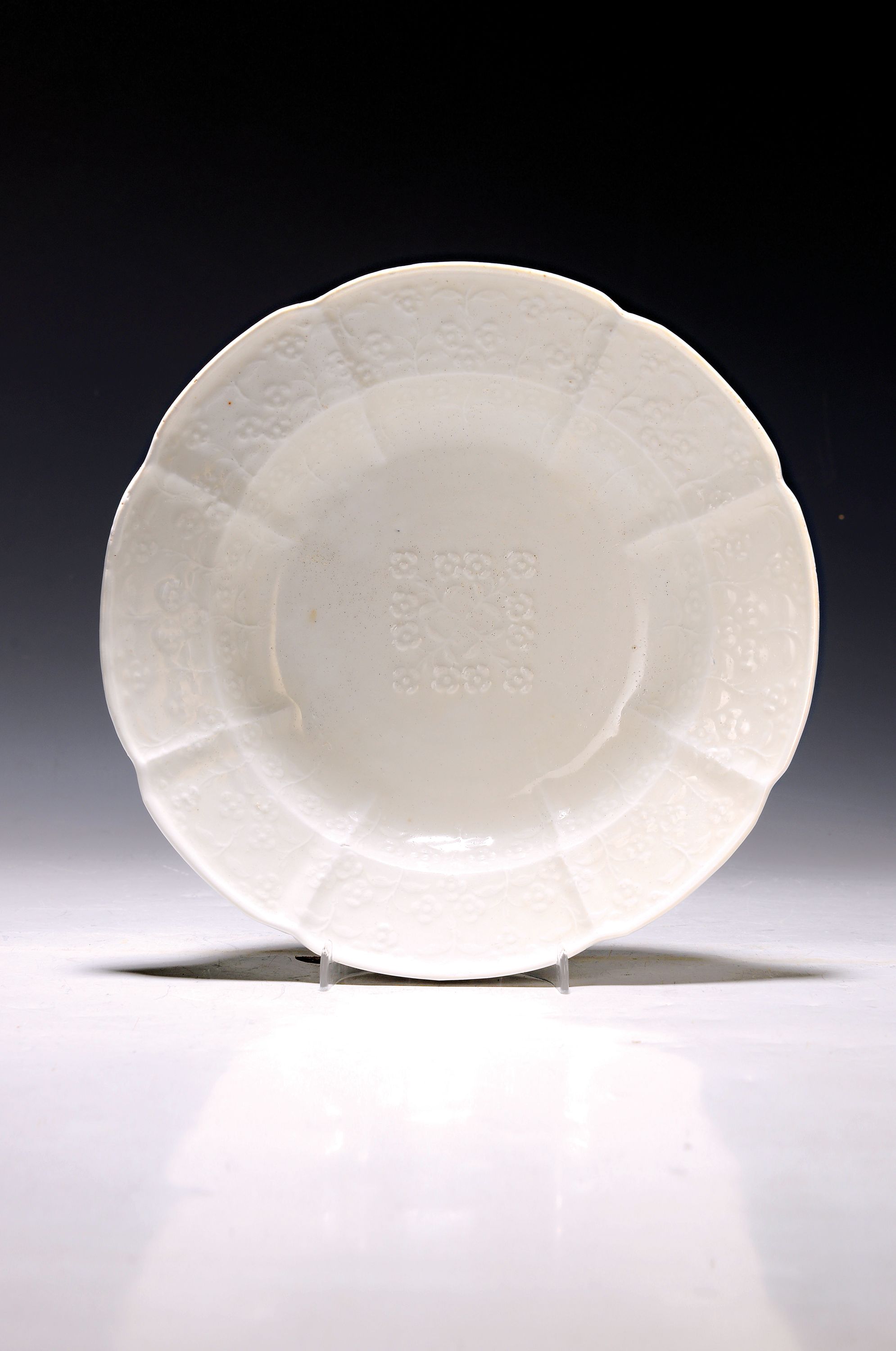Tiefer Teller, Meissen, um 1745, aus sächsischen Hofservice, Weißporzellan, Reliefdekor aus Blüten, unterglasurblaue Marke, restauriert, D. 23,5 cm
